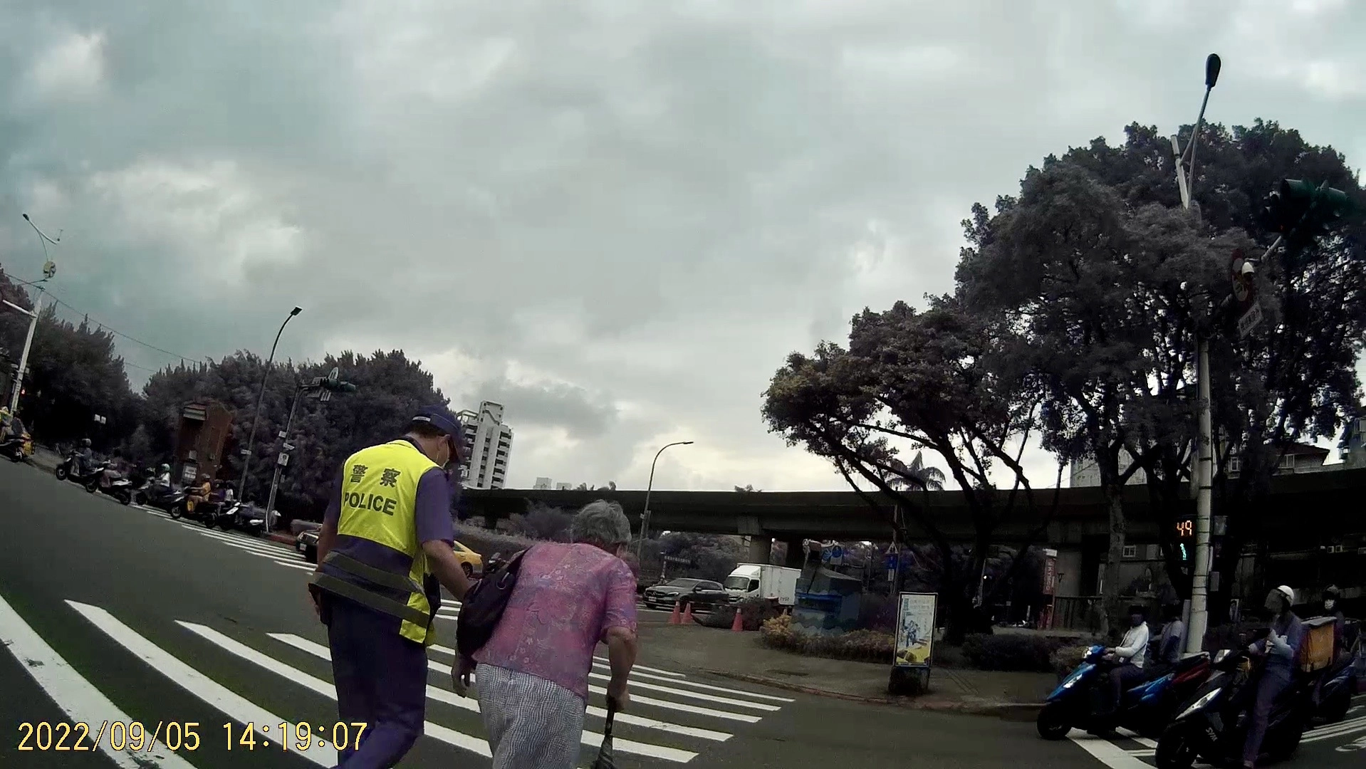 臺北市保安警察大隊吳中隊長迅速下車攙扶老婦人,等行人號誌綠燈後陪同過馬路至安全處。