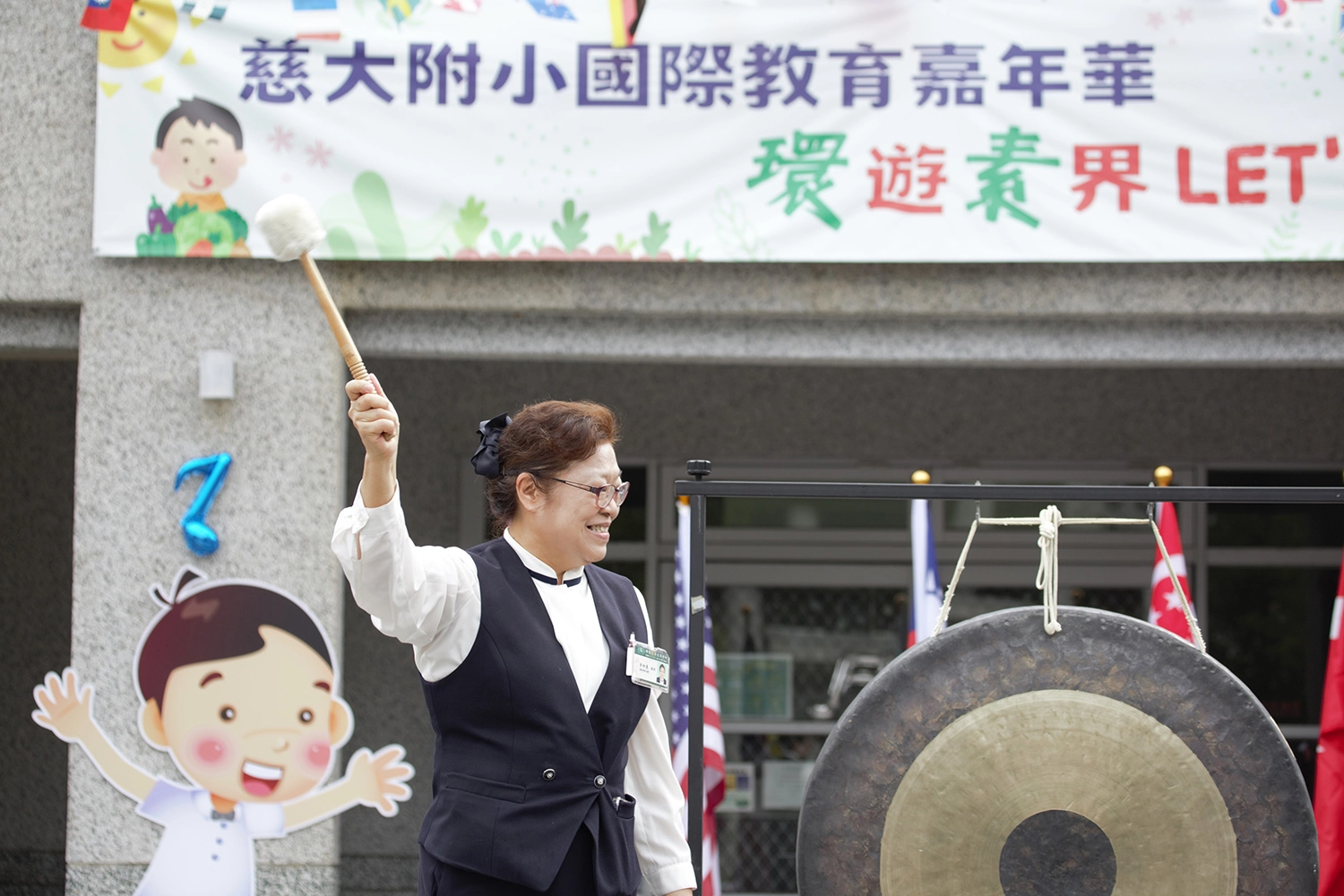 李玲惠校長敲響愛心鑼,慈大附小國際教育嘉年華~「環」遊「素」界Let’s go兒童節慶祝活動。