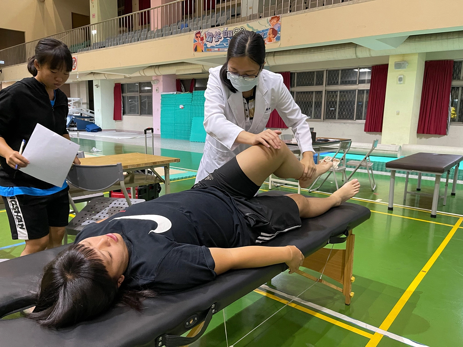 梁雅淳醫師(右)以中醫傷科手法為選手緩解腰部與腿部疼痛。
