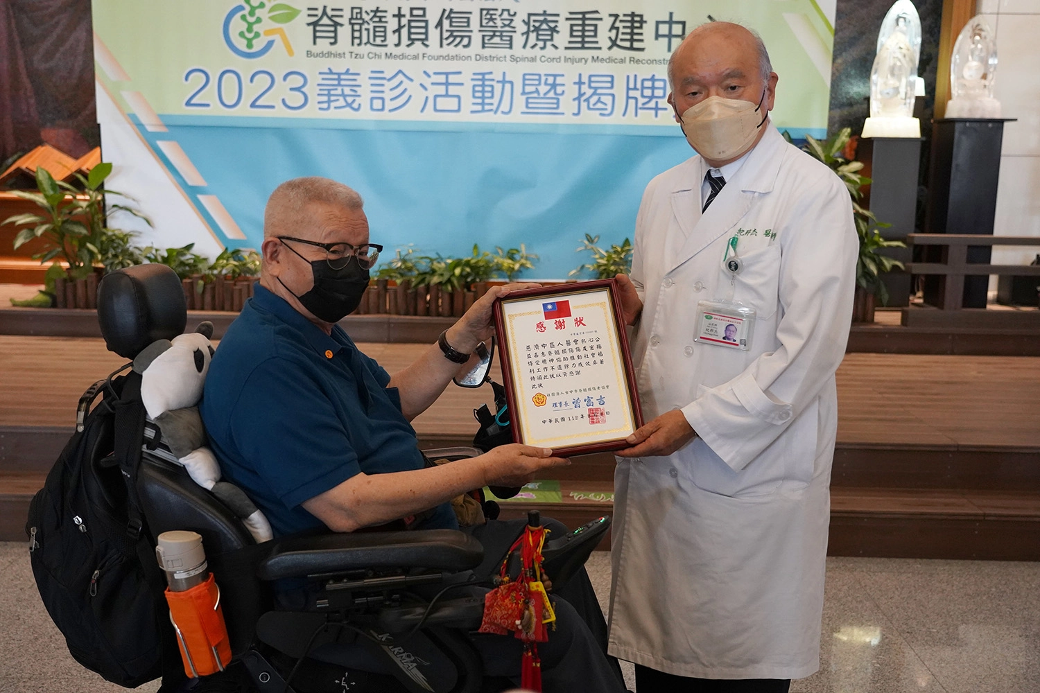 臺中市脊髓損傷者協會理事長曾富吉(左)致贈感謝狀感恩慈濟人醫會定期舉辦義診,由紀邦杰醫師(右)接收。