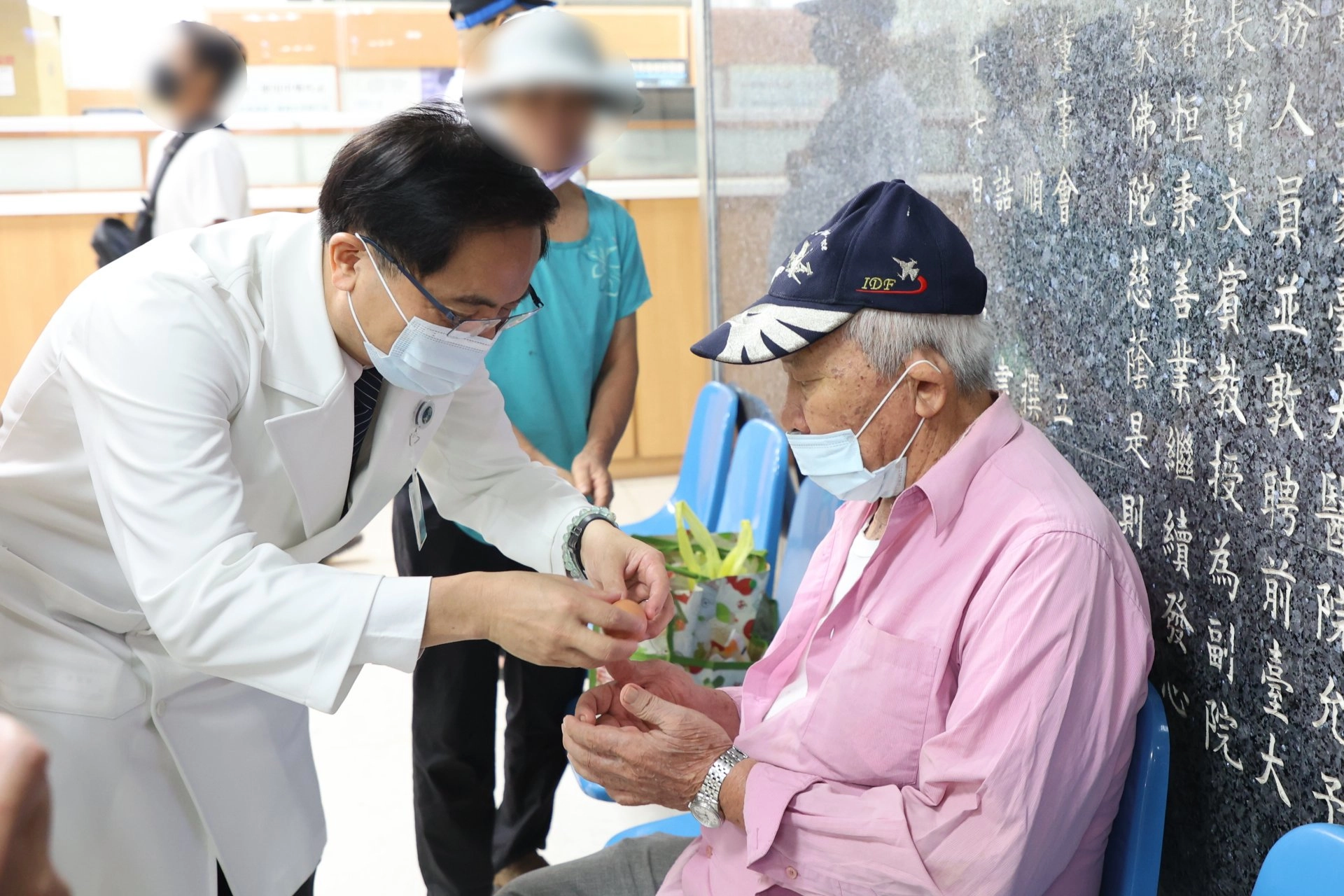 志工室主任顏靜曦也準備了喜氣洋洋的紅蛋,由林欣榮院長、醫務秘書李毅代表,在大廳與病人及家屬分享院慶喜悅。