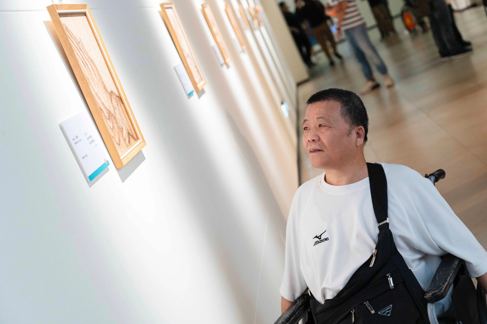 身障創作者慶順在展場中欣賞自己的作品