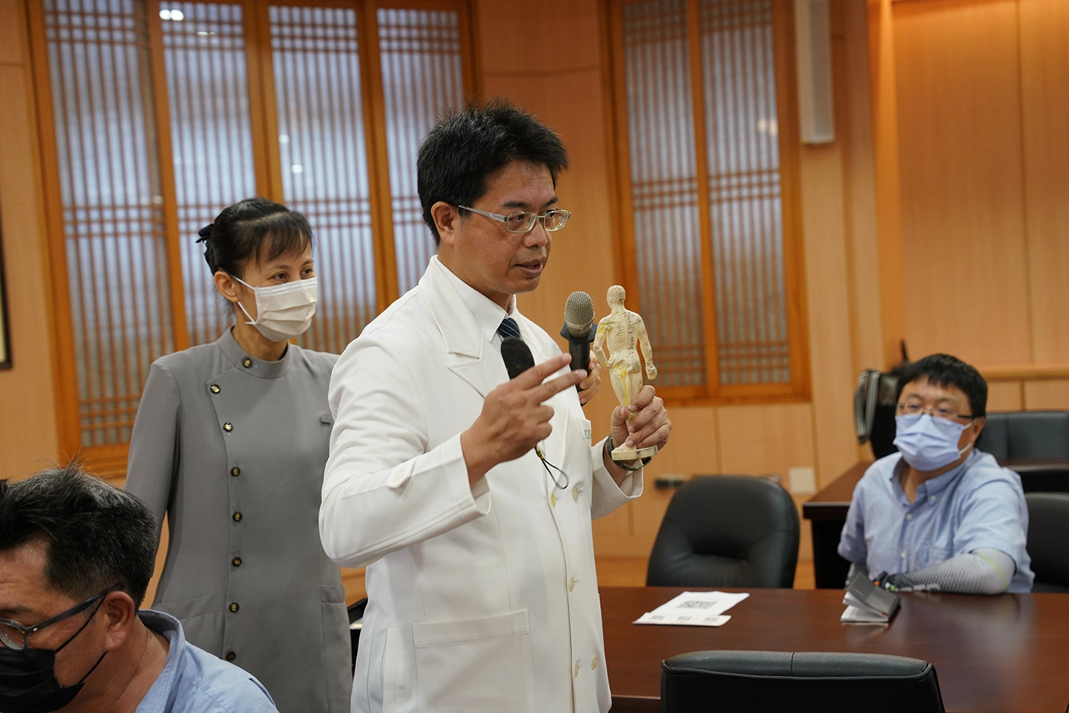 花蓮慈院何宗融副院長,順著經絡示範刮痧技巧。