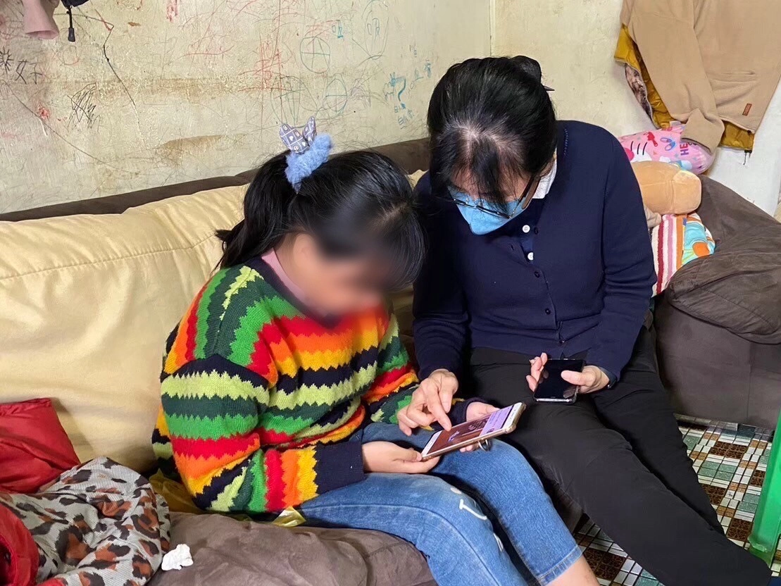 慈濟志工陪伴阿英的女兒,鼓勵上進。