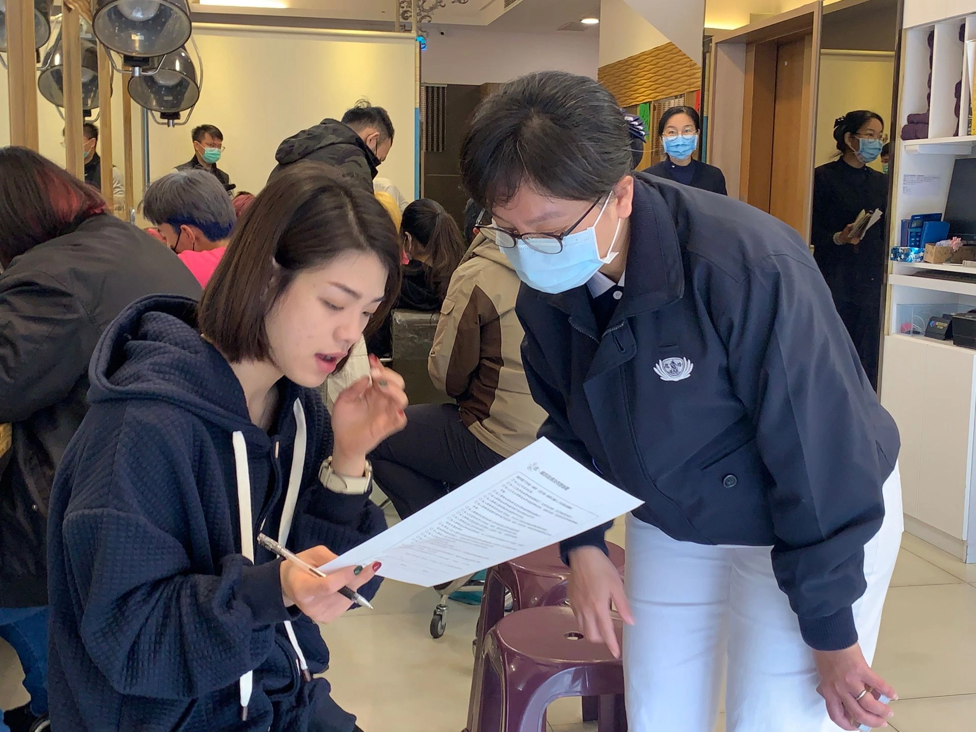慈濟志工在曼都髮廊花蓮店協助與解說造血幹細胞志願捐贈建檔同意書的填寫,隨時提供服務。