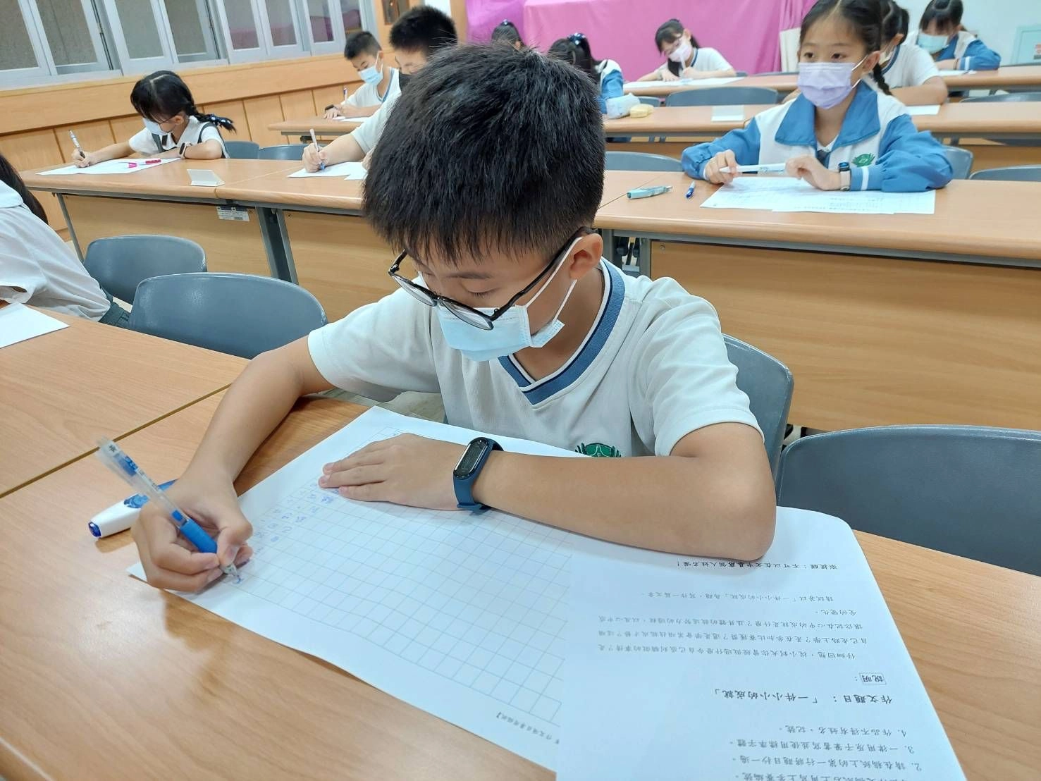 孩子振筆疾書,要把腦中的文字,轉化為一篇邏輯清晰的作文。