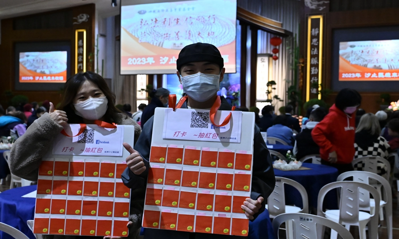 承擔打卡、抽紅包的青年志工周季萱、黃右宇,邀約民眾打卡掃描按讚,抽紅包,為自己帶好運。