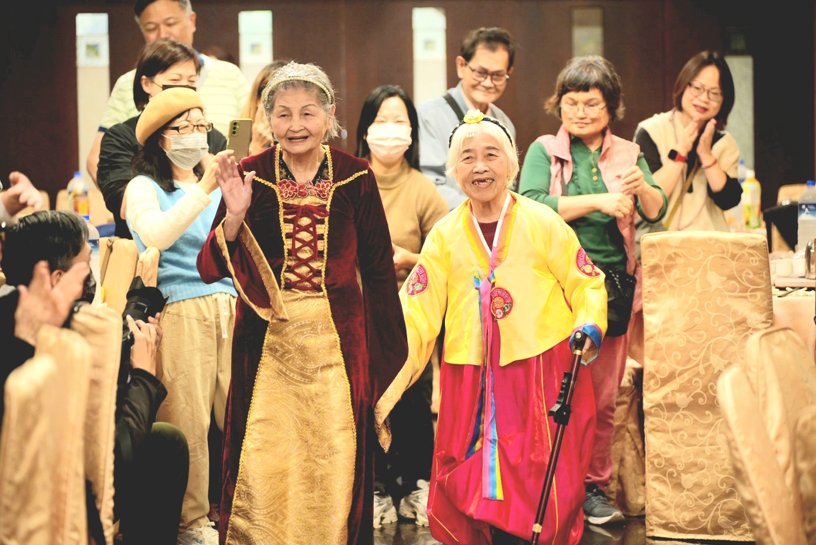 高齡91歲的金枝阿嬤(左)穿著皇后禮袍,和身穿韓服的素月阿嬤一起歡喜進場。
