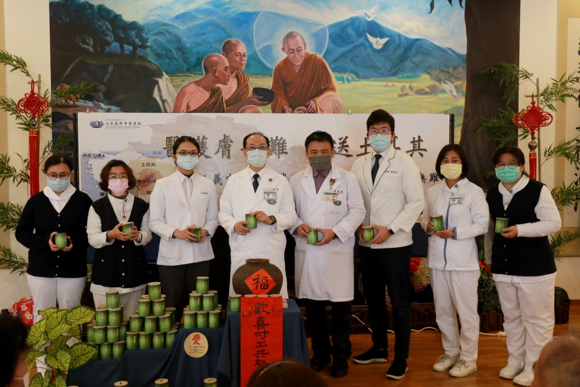 葉家舟院長(左四)帶領醫護團隊齊聚佛陀問病圖前,為土耳其災民祈禱並募心募愛。