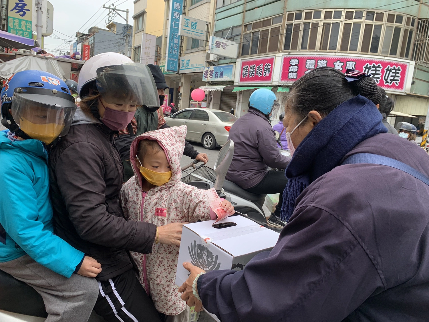 2月25日彰化慈濟走上街頭募心募愛,一位女士帶著小孩來捐款。(圖為慈濟基金會提供)