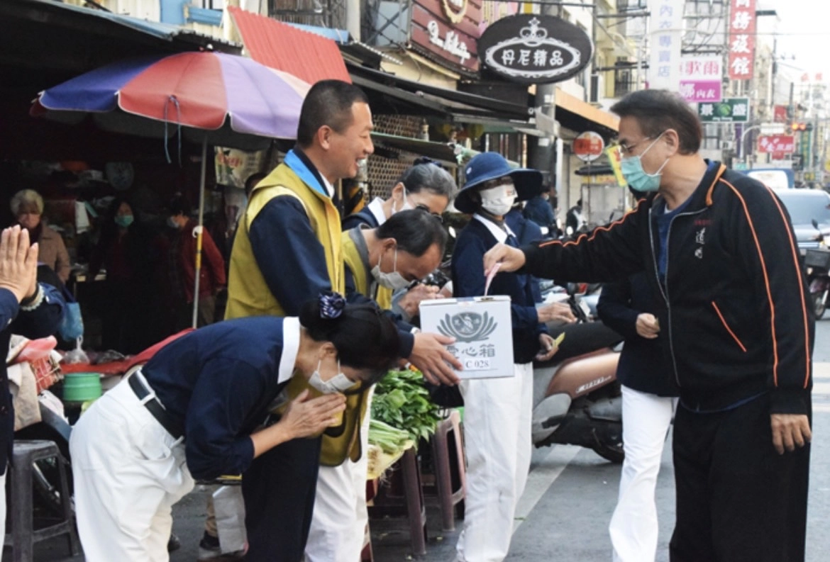 在菜市場加入勸募行列的東港鎮鎮長黃禎祥(左二),也一起穿起慈濟背心站在街頭參與勸募。