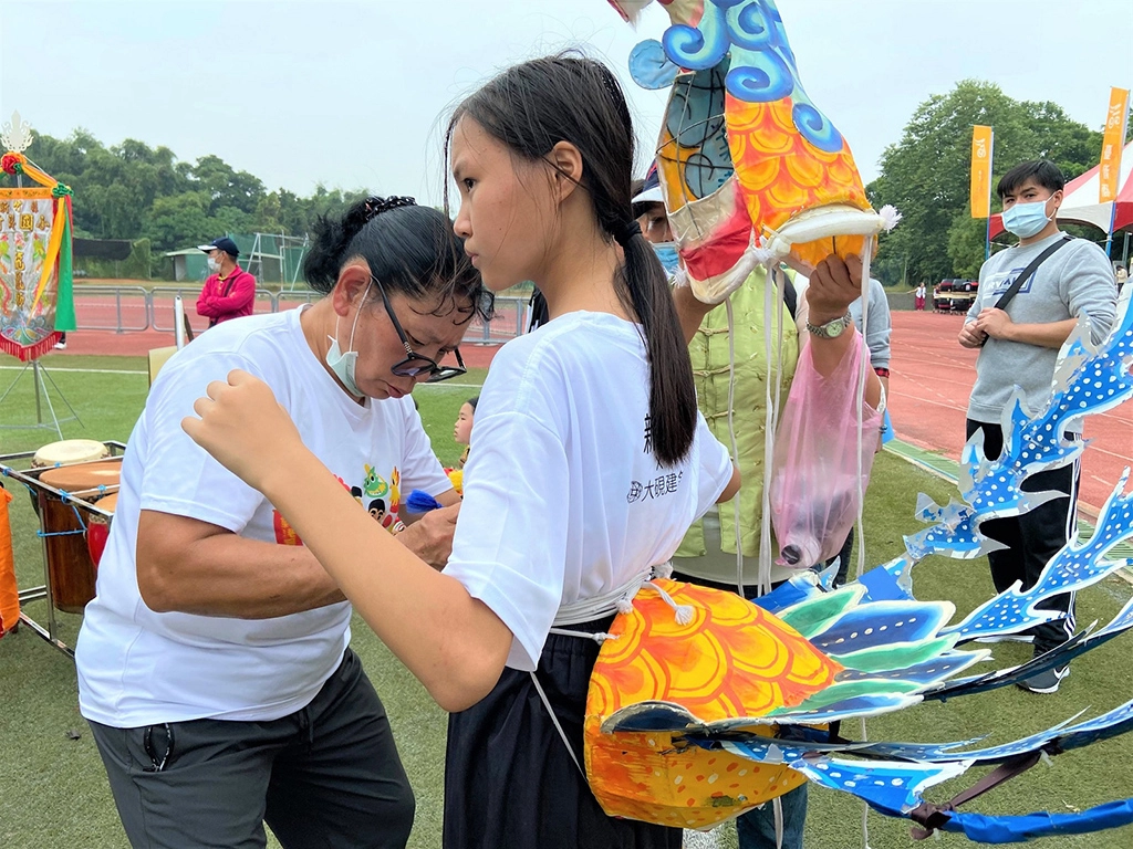 鄭宇芝老師賽前親手幫學生繫緊繩,如給予他們力量及祝福。