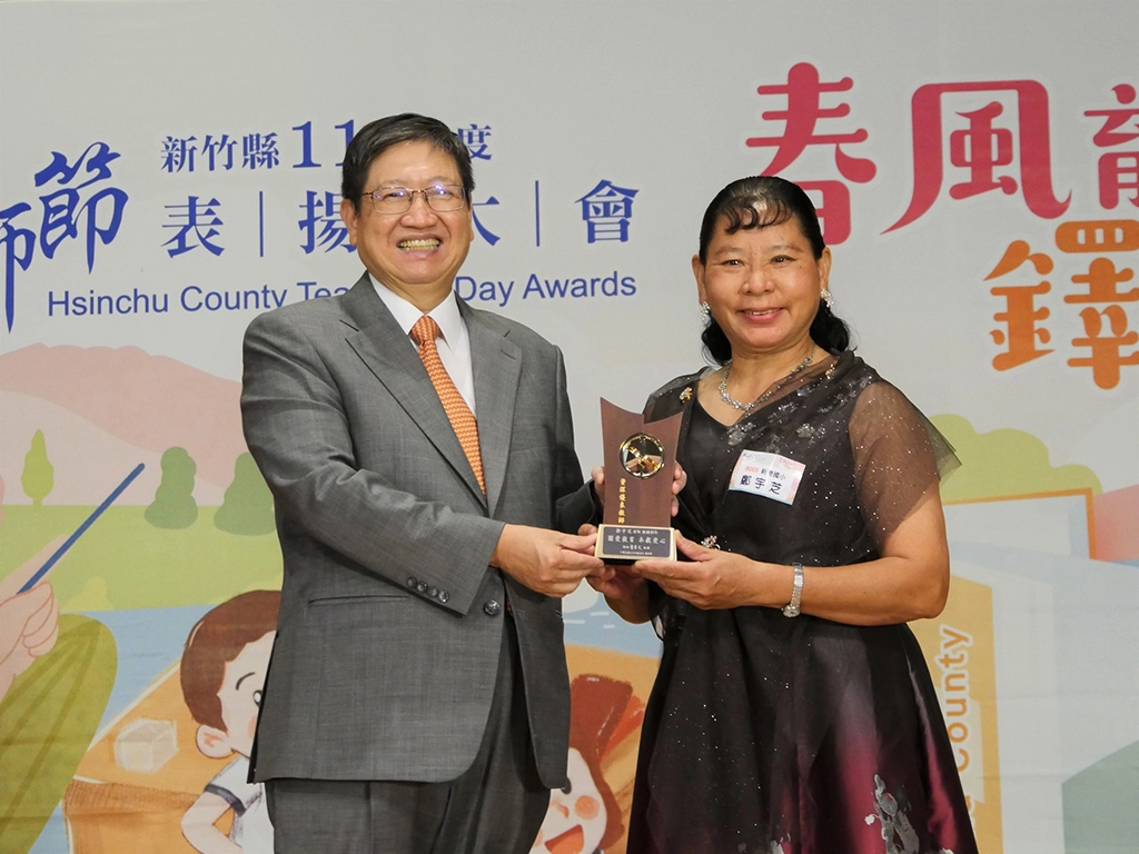 投入新港國小舞獅隊27年,同時服務教育屆滿40年的鄭宇芝老師(右)上台接受表揚。