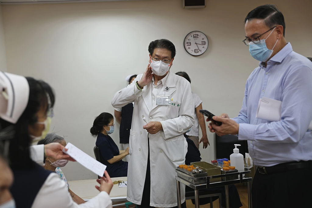 張俰賓博士與新加坡慈濟基金會主管至花蓮慈院中醫門診,觀摩中醫部針灸科主任林郁甯為患者針灸治療,並用手機拍照記錄細節。