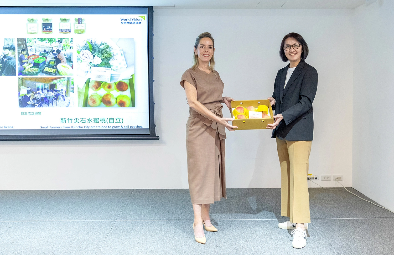 台灣世界展望會會長李紹齡(右)贈送巴拉圭準第一夫人Leticia Ocampos(左)由展望會國內服務團隊培力社區自立後出產的水蜜桃。(台灣世界展望會提供)