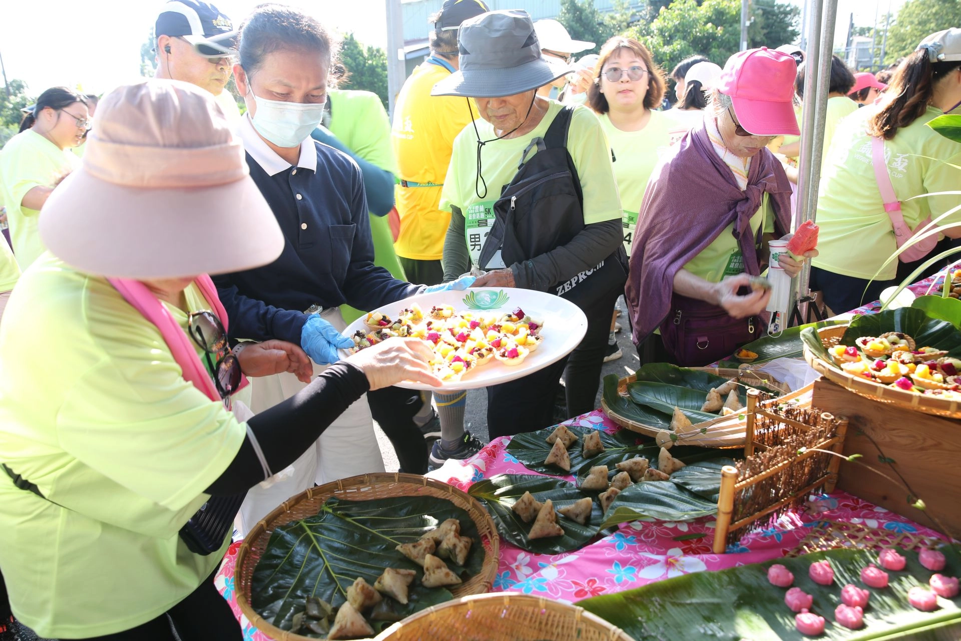 天氣炙熱,參加5K跑者快樂來到一口蔬食補給站,志工端上點心為跑者補充量能。