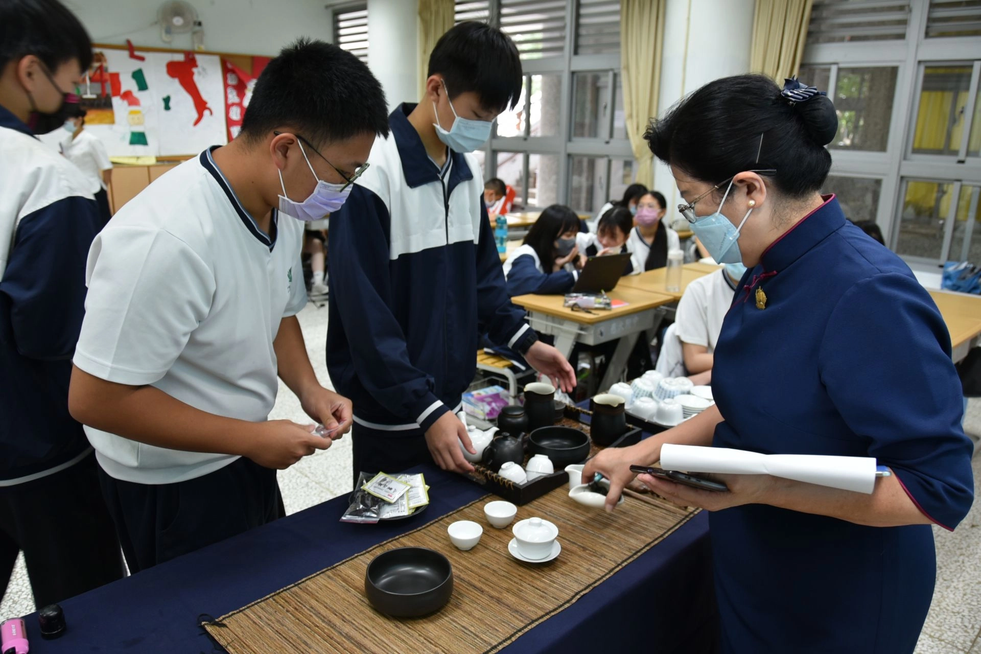 靜思茶道老師指導學生如何擺設茶具讓成果發表順利進行。