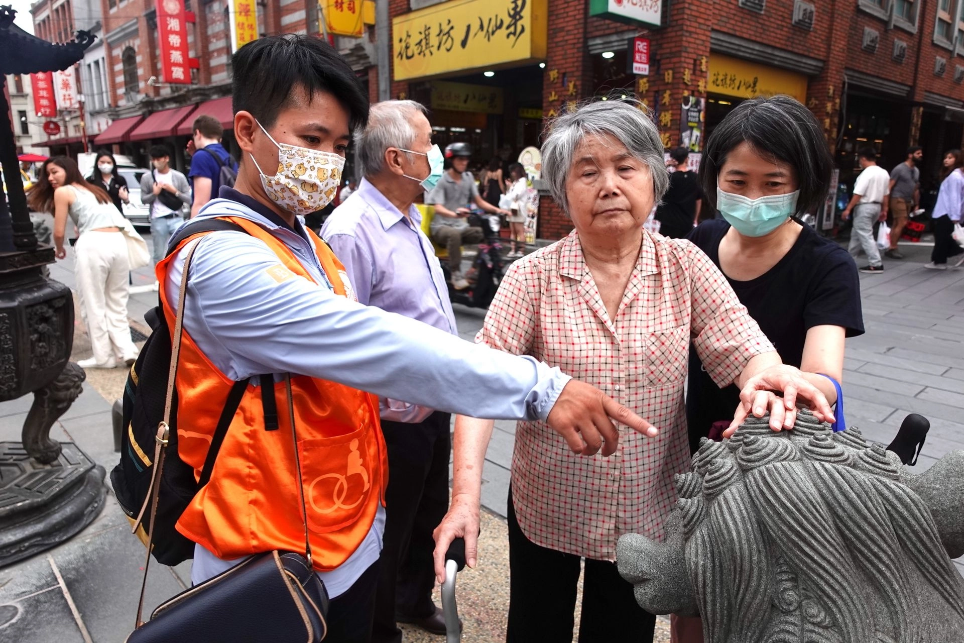伊甸志工陪伴視障朋友及照顧者,透過觸覺、聽覺體驗大稻埕傳統文化。
