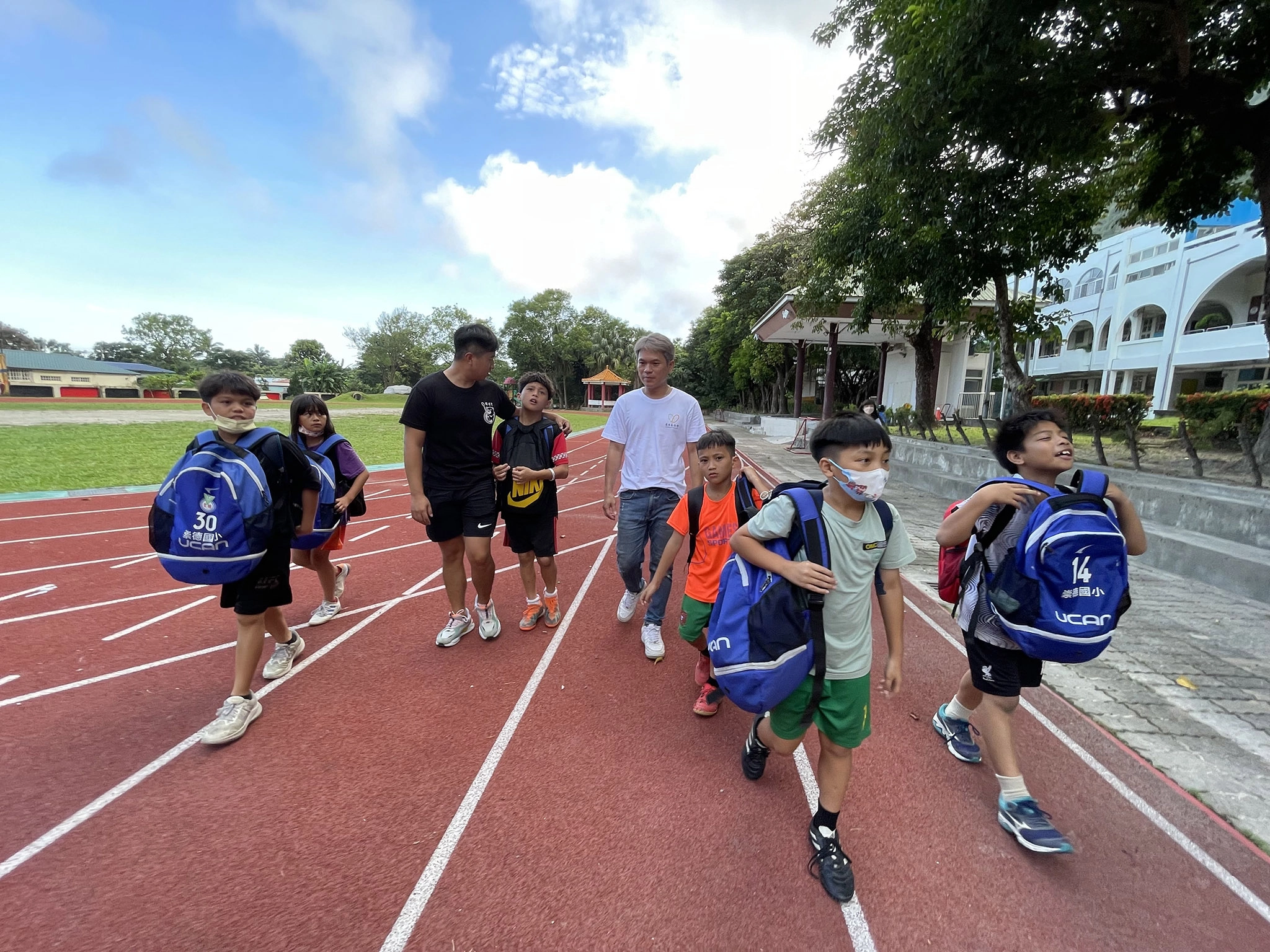 慧治公益大使舒米恩(右4)親自走進崇德國小的校園,與「崇德小學堂」課後照顧班的阿浩老師(左3),一起去接小朋友們放學。
