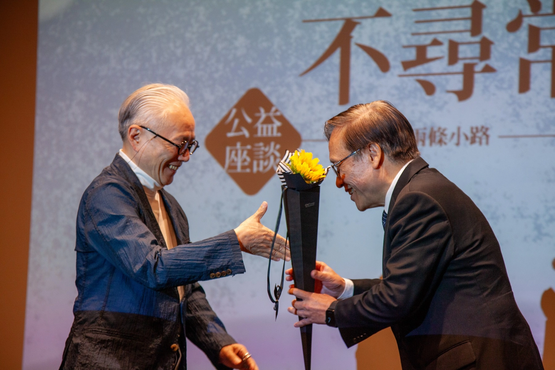 姚仁祿(左)獻花給簡守信祝福,像向日葵綻放光芒。