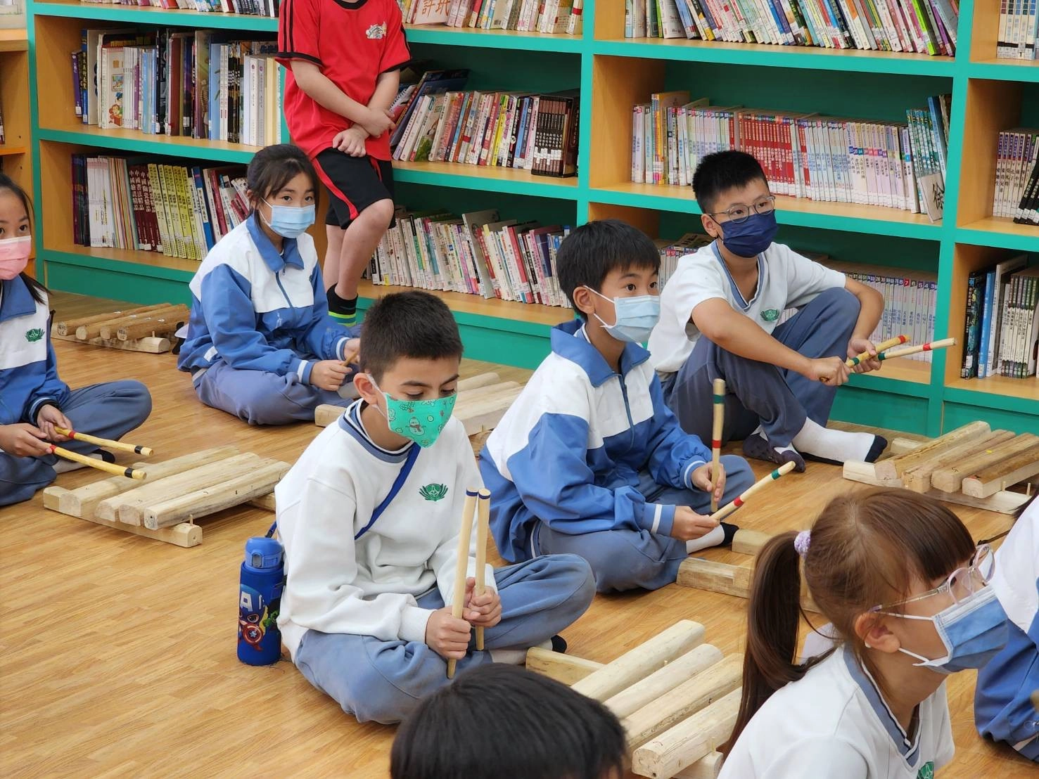 慈小學生認真聽老師指導木琴的演奏方式