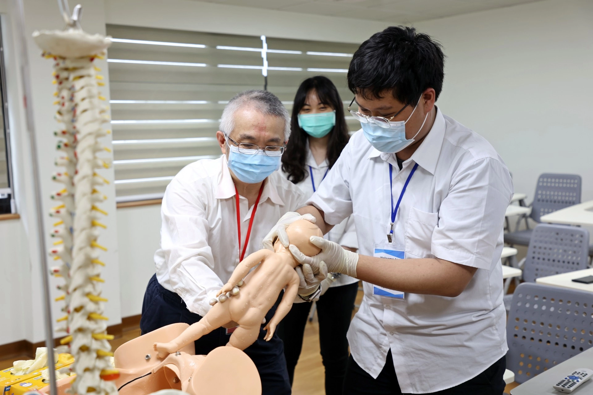 高聖博主任指導醫學生,當胎兒從母親的產道出來時,該如何擺放手勢、如何調整角度,才能夠以最安全的姿勢讓寶寶平安誕生。