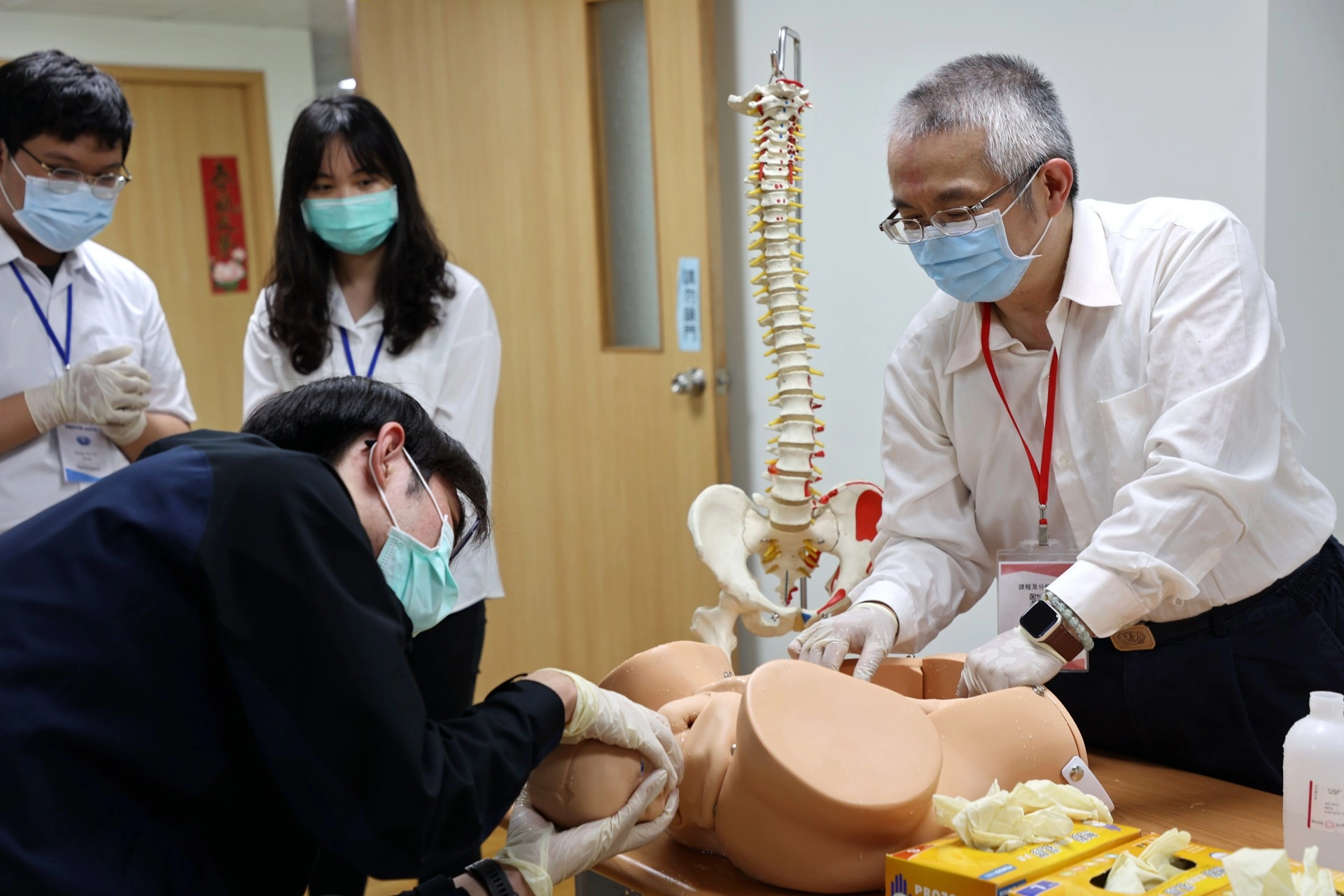 高聖博主任指導醫學生,當胎兒從母親的產道出來時,該如何擺放手勢、如何調整角度,才能夠以最安全的姿勢讓寶寶平安誕生。