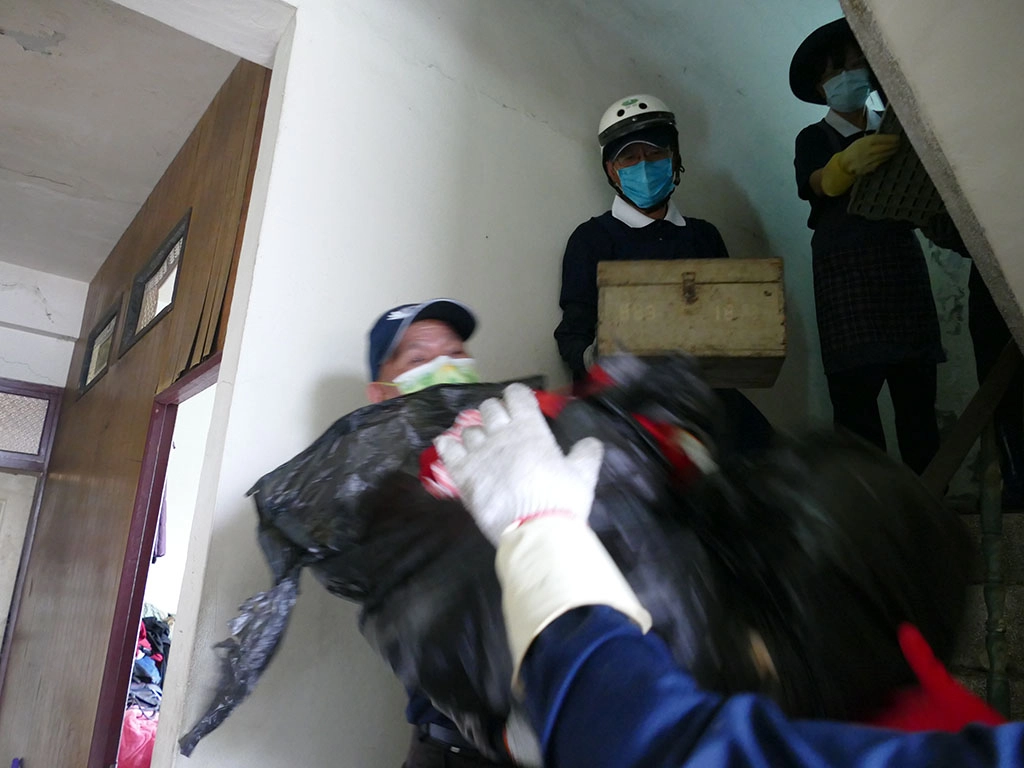 南投慈濟志工為獨居長者清理環境,志工以接力方式將家具與廢棄物搬出。