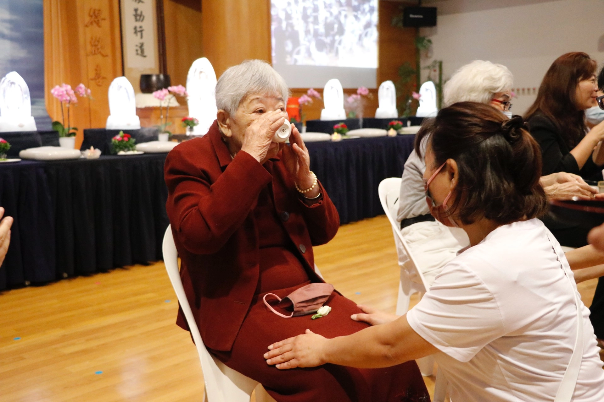 志工規劃「孝親奉茶及獻花」活動,孔戴秀盞接起女兒孔德蓮的奉茶,滿是歡喜。