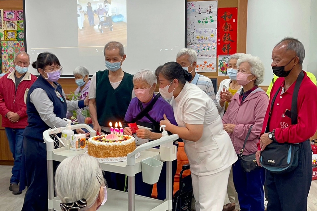 失智共照中心團隊為楊奶奶慶祝百歲生日,祝福她康復後可以再回來與共照中心的老師和同學們一起上課。