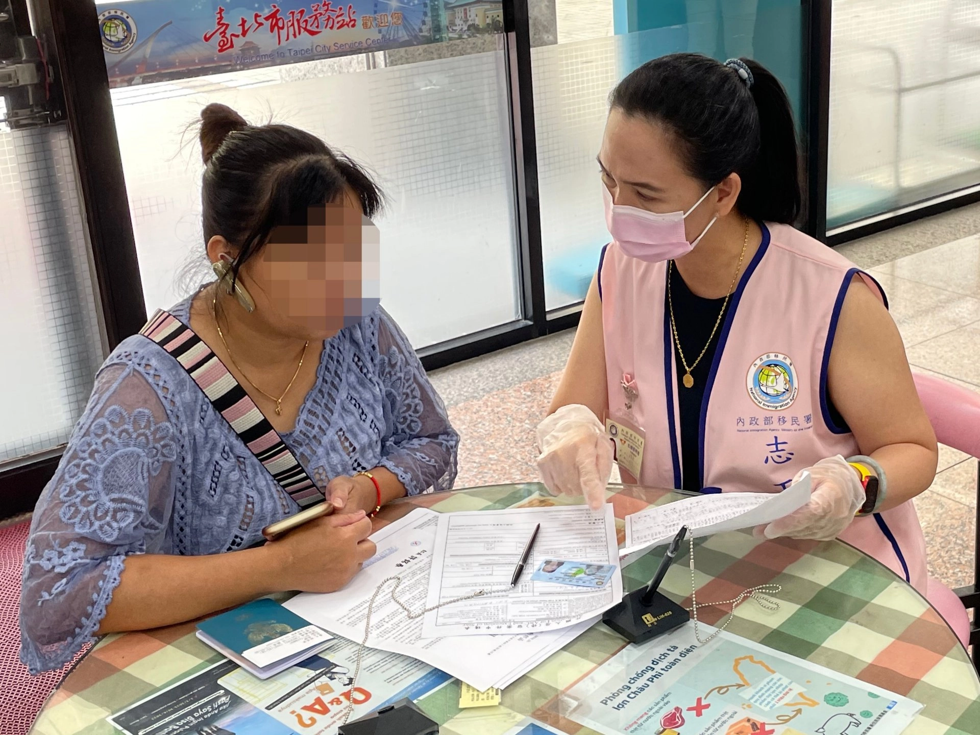 吳寶英(右)平時對不懂中文的外來人士積極友善、不厭其煩仔細聆聽及解說協助申辦案件。