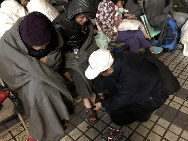 2月6日花蓮強震,慈濟志工關懷撤離民眾,何日生在第一時間即時趕到現場,為長者置放暖暖包於鞋中,讓手腳增添暖意。