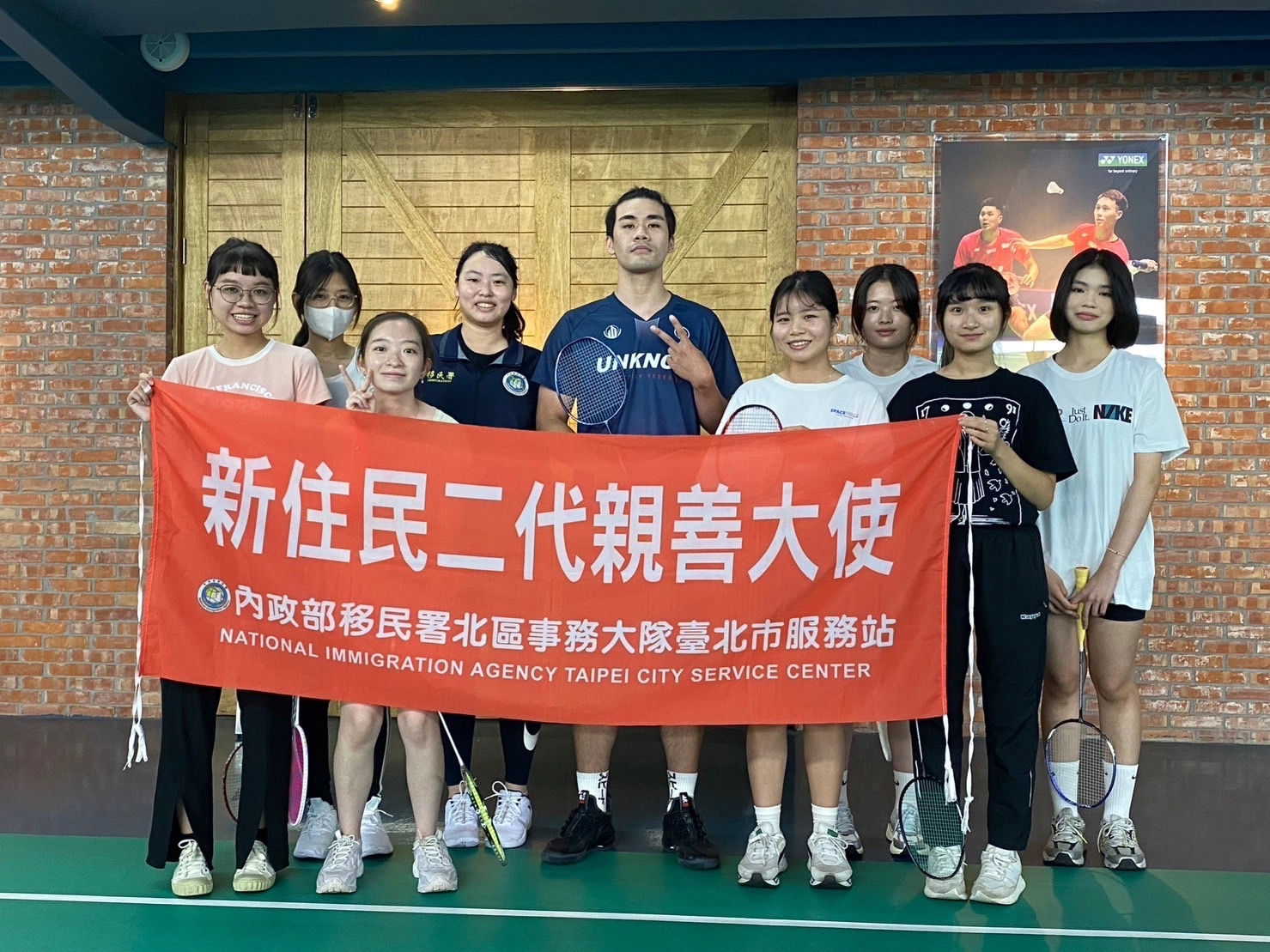 新住民二代親善大使體驗羽球競賽的魅力。(中間為羽球教練朱浩東,右四為曾心怡)