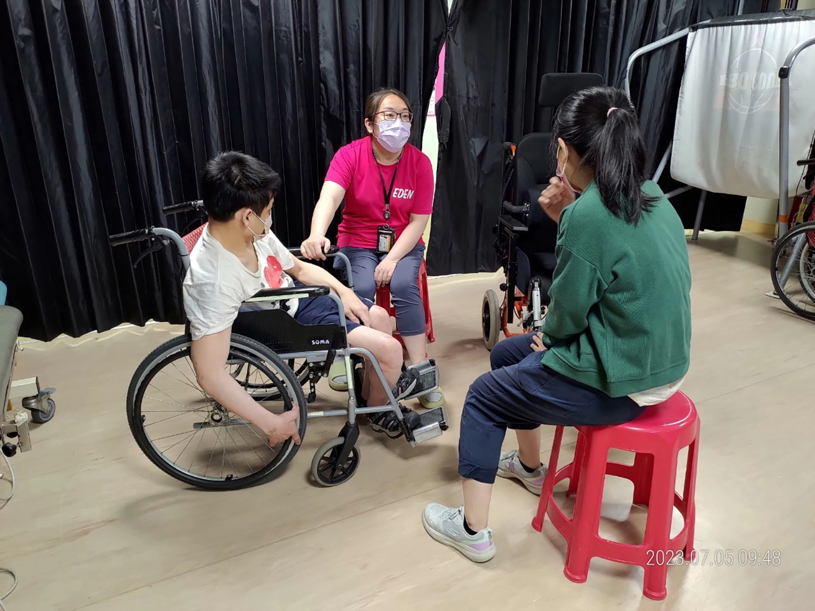 楊沛璇(左二)為喜歡外出的腦性麻痺患者挑選合適的輔具,避免他日後因脊椎側彎壓迫胸腔,造成呼吸衰竭的危險。