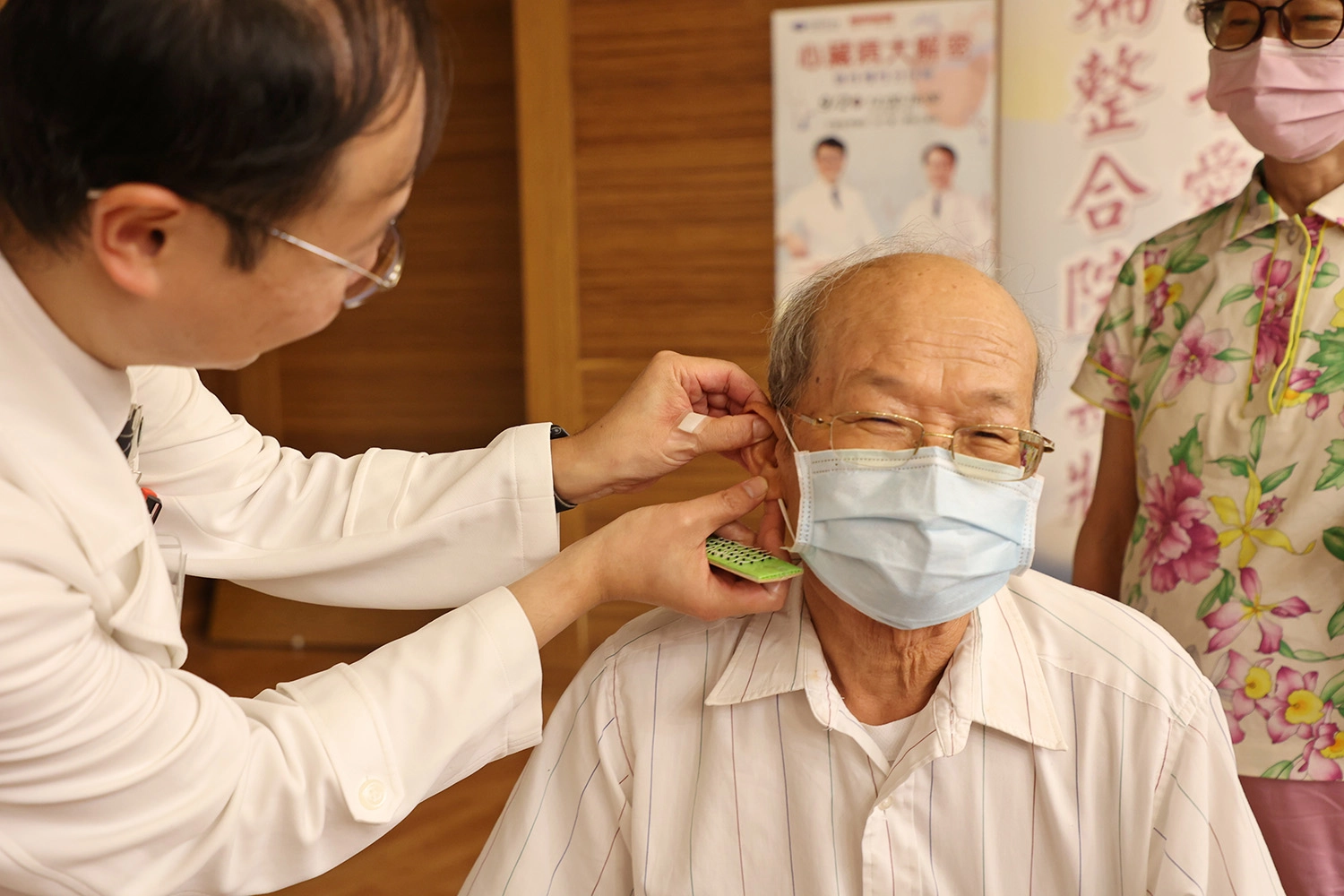 林經偉主任為民眾貼上耳豆貼,祝福大家都能護心養心,健康安心。