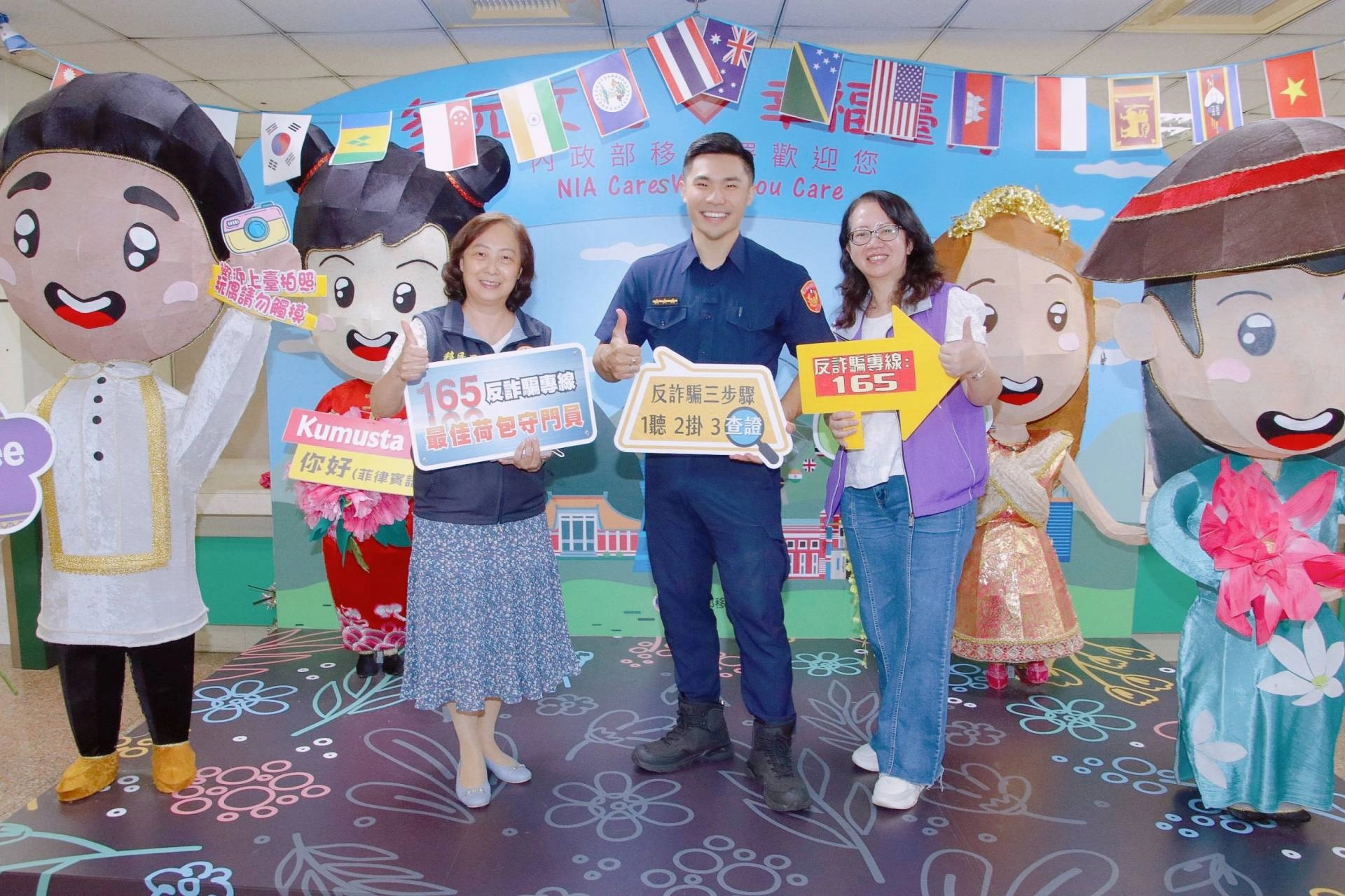 外型酷似知名演員阮經天的三重分局的警員郭紘銘(中)現身移民署「新住民防詐騙快閃宣導活動」。右為警察廣播電臺臺北分臺分臺長林慧瑛、左為移民署臺北市服務站主任蘇慧雯。