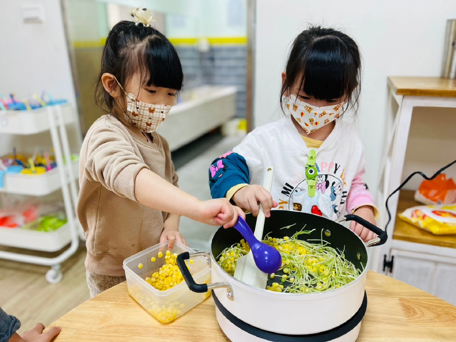 幼兒實際動手烹調玉米炒綠豆芽料理(桃園市大和非營利幼兒園提供)