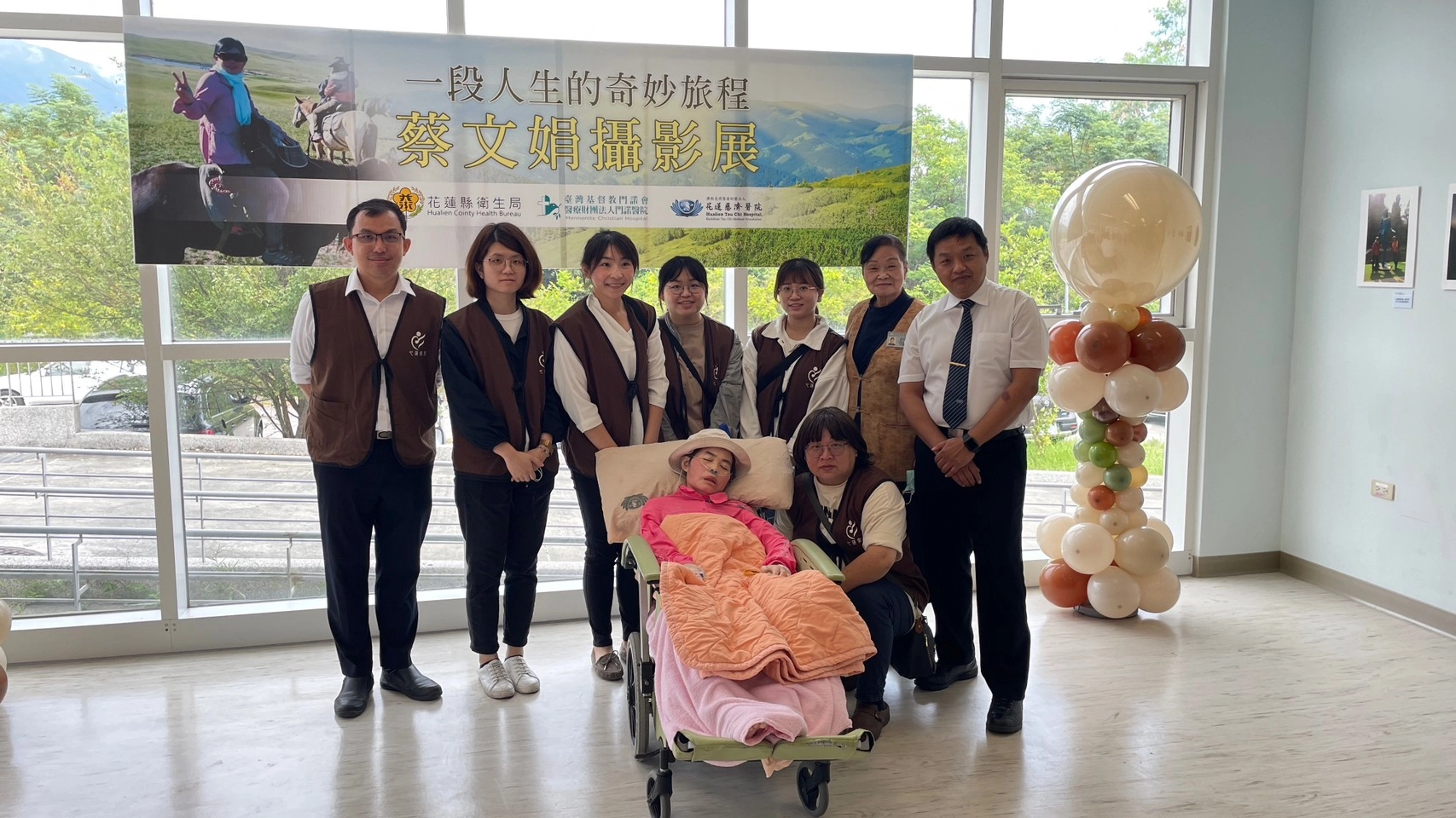 心蓮病房團隊啟動心蓮旅行社圓夢計畫,包括心蓮病房主任謝至鎠(後排右一起)、心蓮病房志工蔡秋雀、護理師何佩秦、林佳慧、鄧淯勻、徐慈憶、新加坡邱德拔醫院陳廉敬Laurence Tan Lean Chin醫師,江青純護理長(前排右一)等人,在九月十七日當天,陪著文娟(前排左一)出席攝影展協助症狀控制及照護。