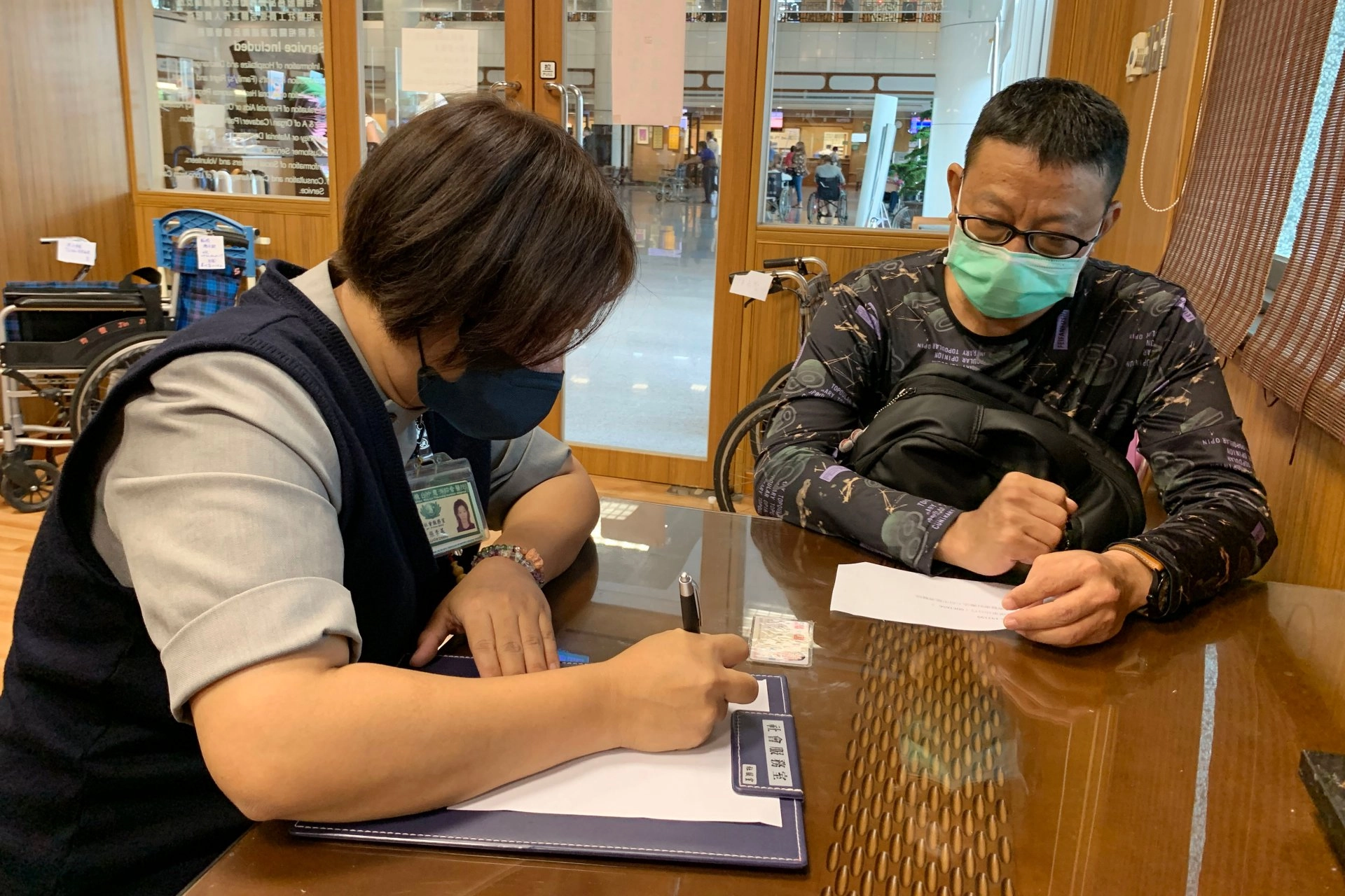 獲大愛肝臟移植的郭先生(右)到台中慈院社會服務室填寫捐款資料,護持醫療體系運作,幫助更多病人。