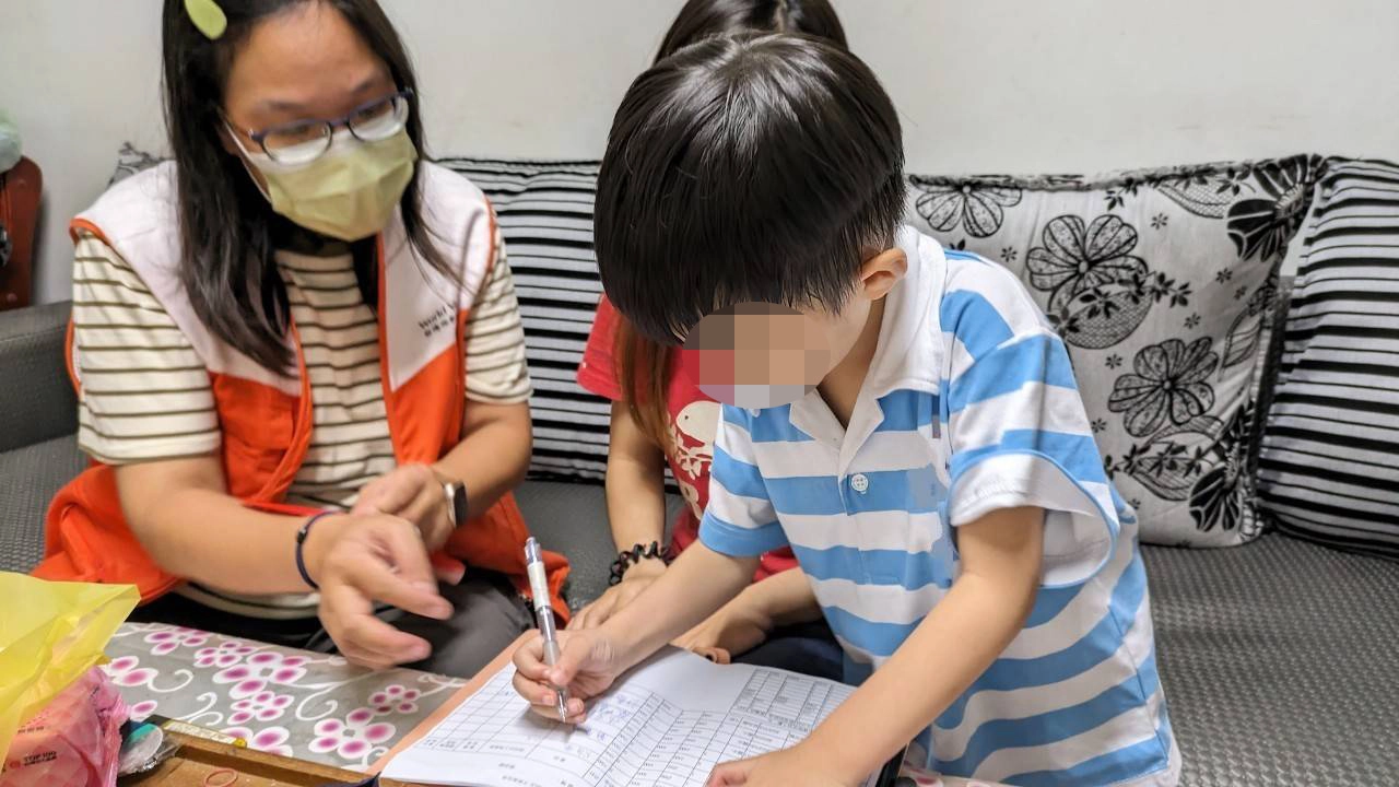 社工員邀請小奕親自簽收營養扶助金。