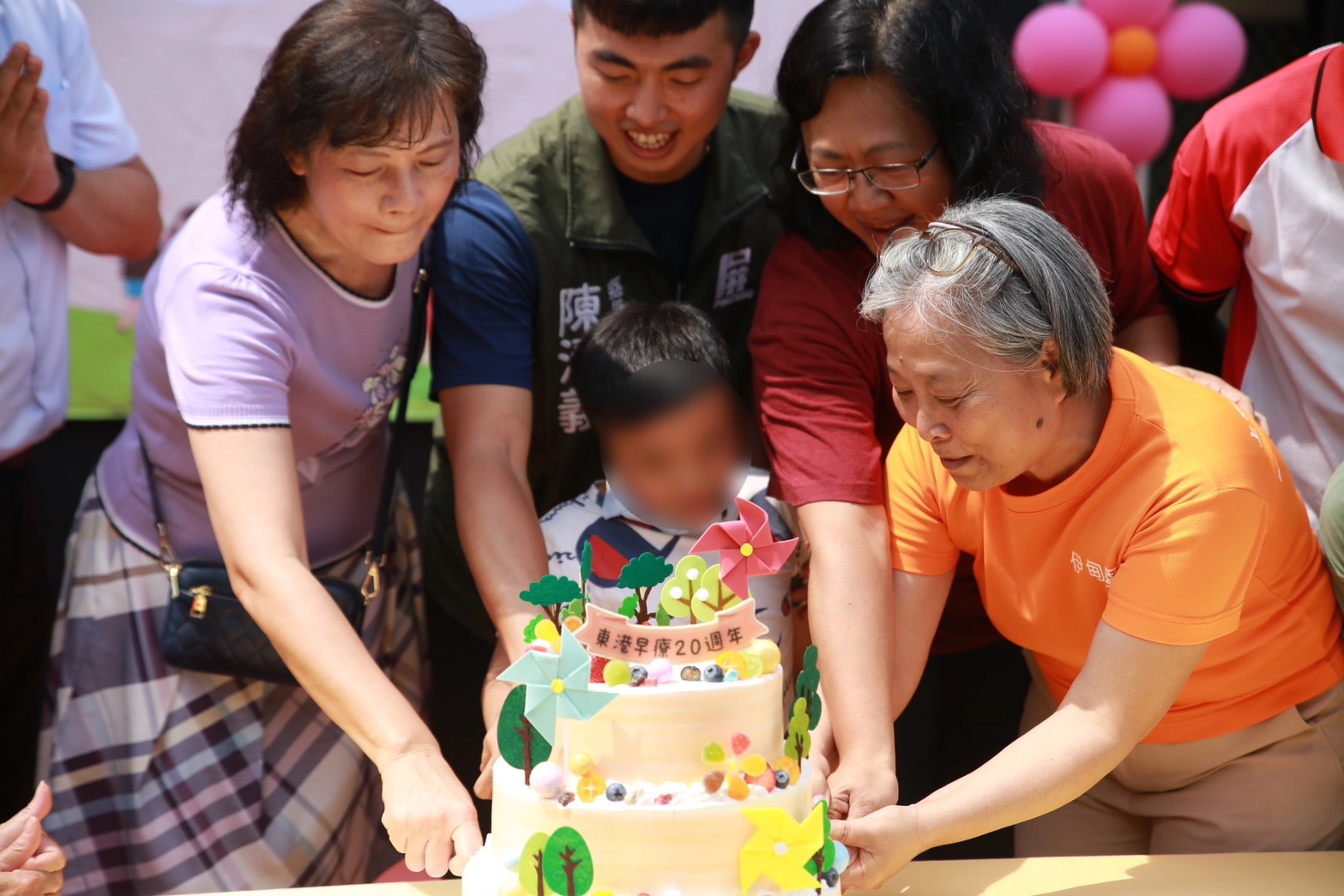 伊甸基金會屏島區區長程錦屏(右)及屏東縣縣長室秘書陳清義(中)、屏東縣社會處婦幼科吳竹萍科長(右2)、東港國小校長簡麗玉(左1),一同切生日大蛋糕
