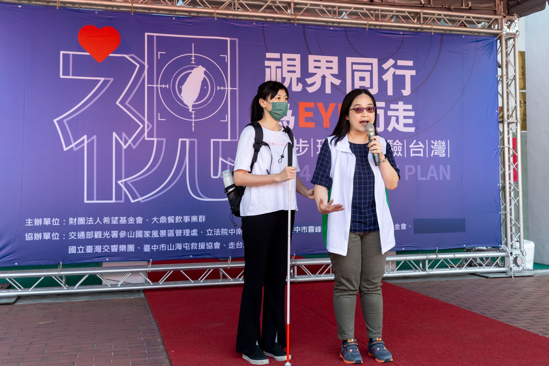 愛盲中區主任莊惠鈞(右)介紹愛盲行動語言「問拍引報」