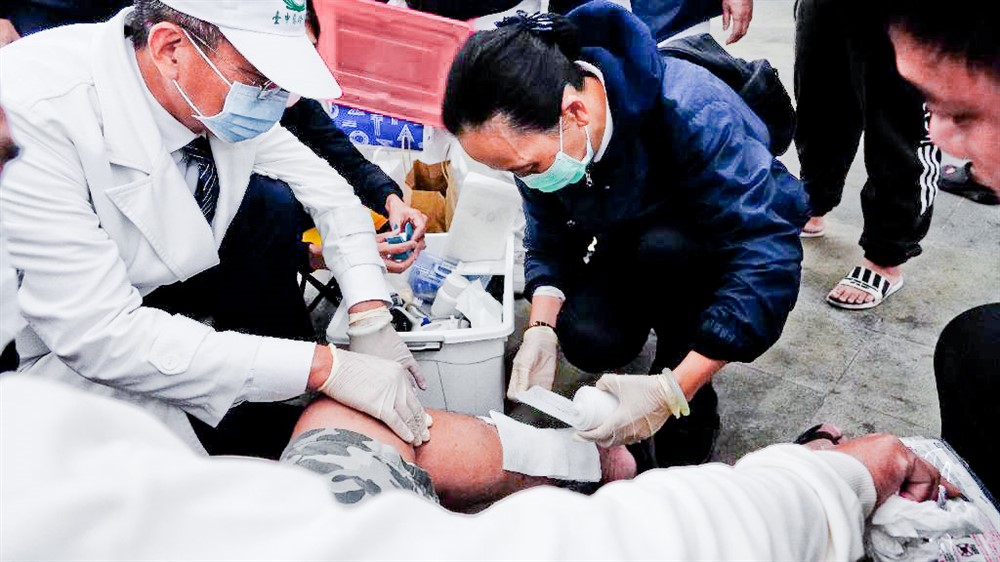 中區慈濟人醫會結合臺中市街友關懷協會,一月五日晚間展開關懷街友活動,林忠義醫師(左)與葉慧芬護理師為街友處理傷口。