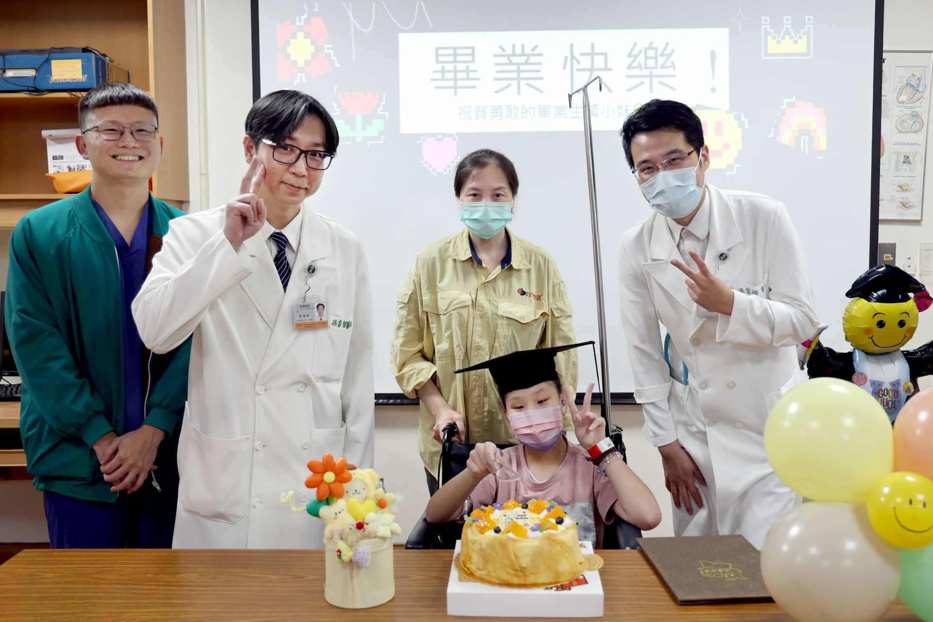 外科部主任張睿智(左二)、兒童心臟科主任秦家翊(右一)一起祝福黃小妹(中前)畢業快樂。