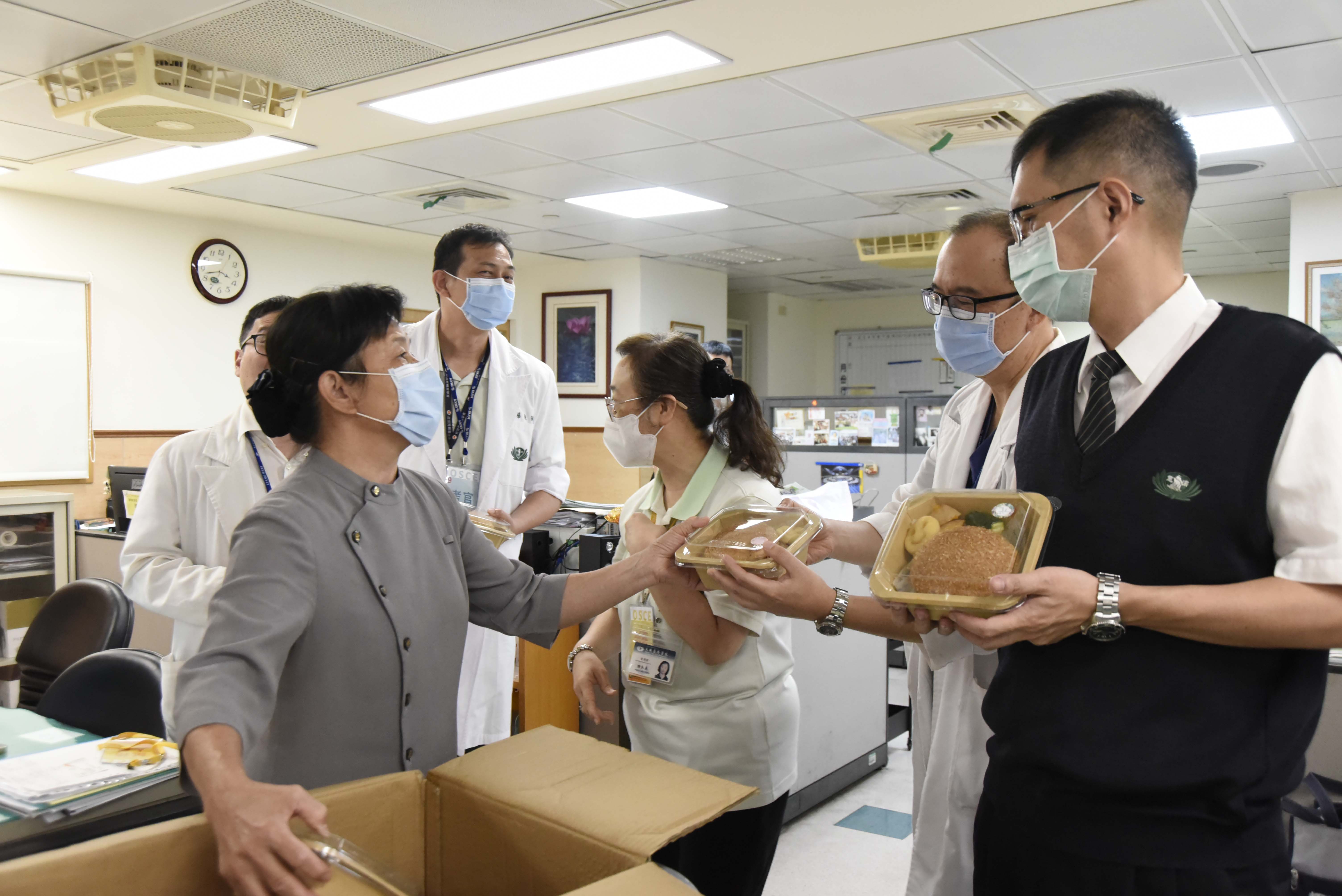 人文室葉璧禎主任分送餐盒給忙碌的同仁。