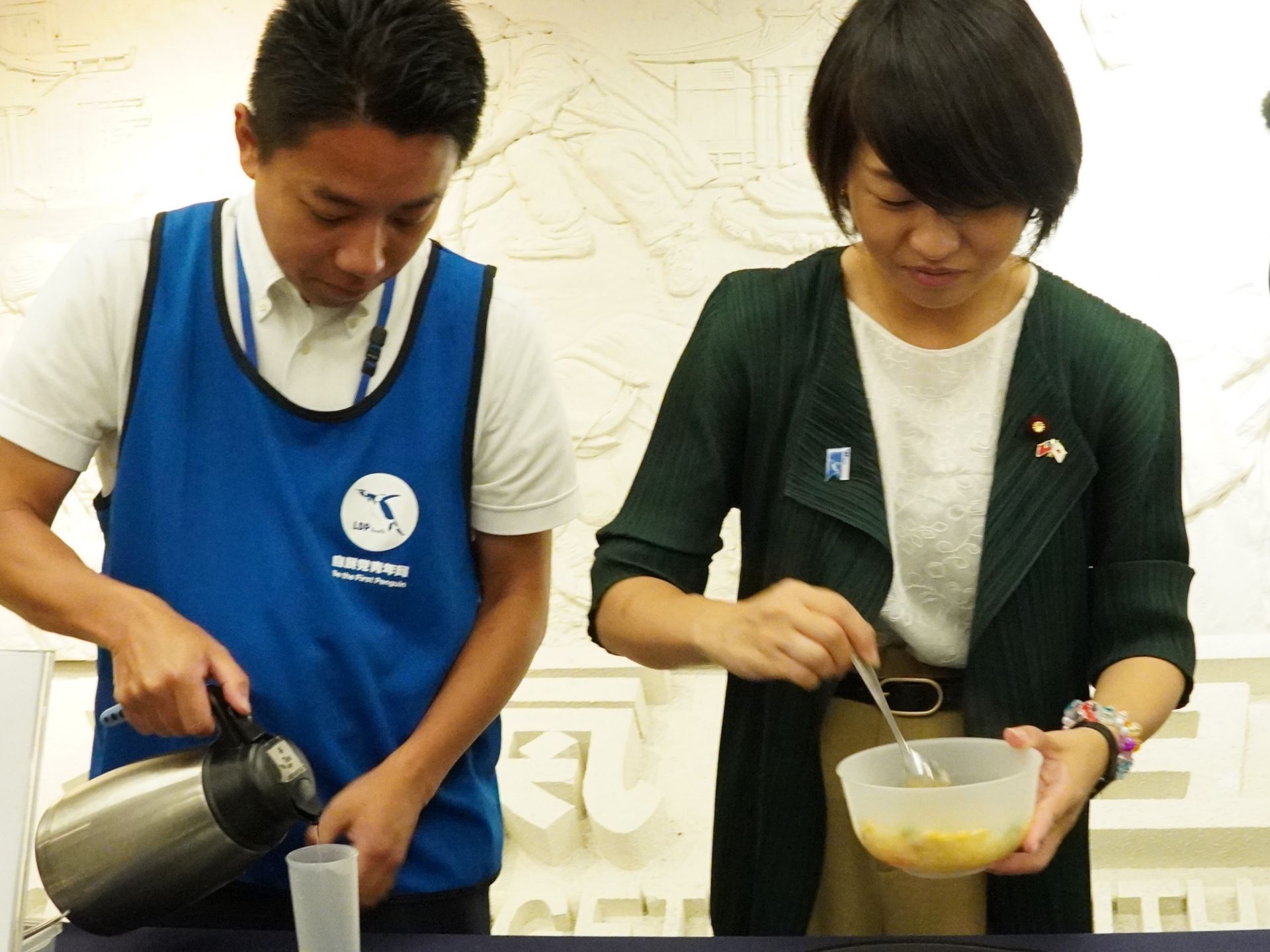 日本自由民主黨青年局局長鈴木貴子(綠衣者)體驗沖泡香積飯,並且表示「おいしい(好吃)」。
