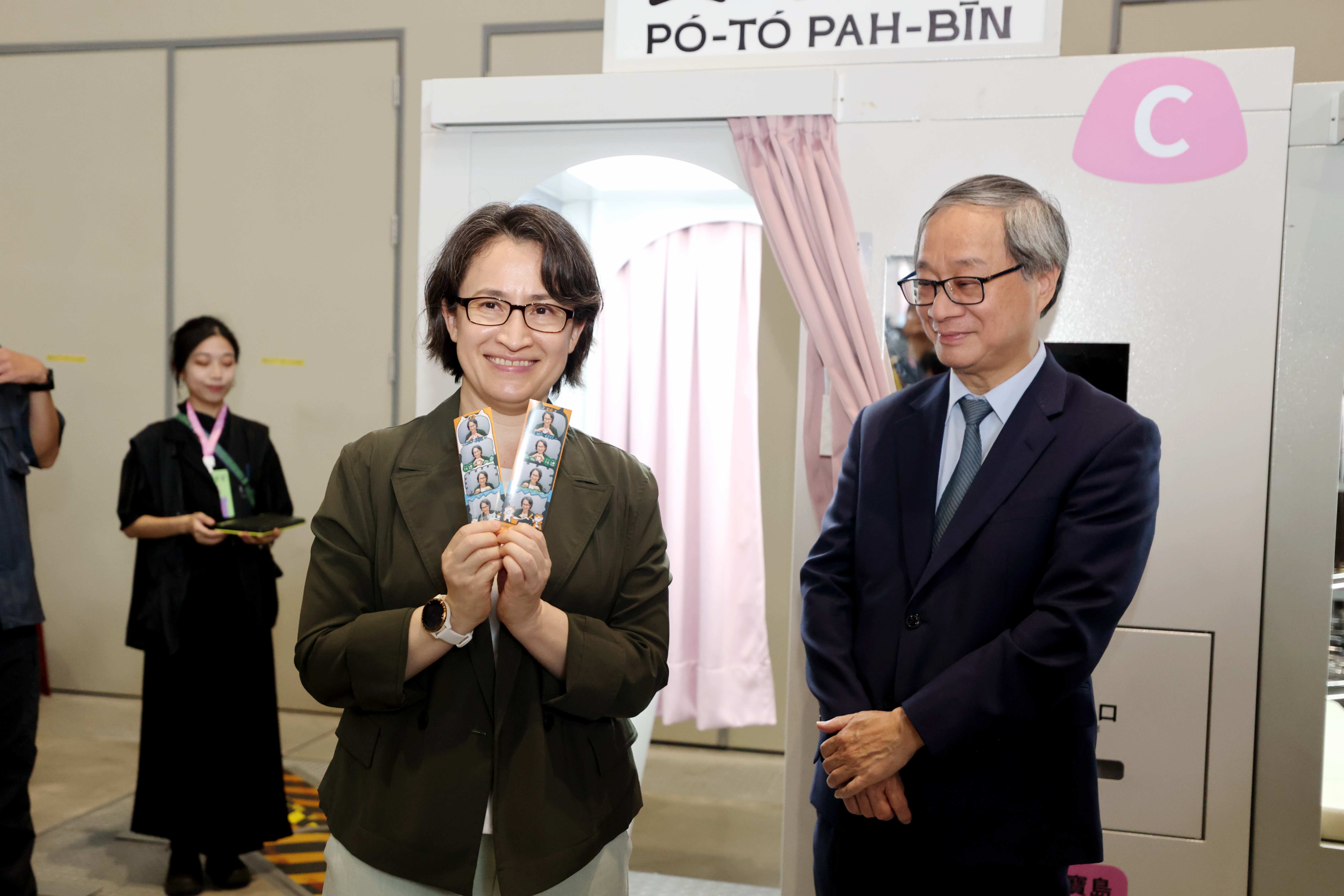 副總統蕭美琴(左)體驗由創作者「美可女子」以花蓮為元素,貓咪搗麻糬及豐年祭的拍貼機。