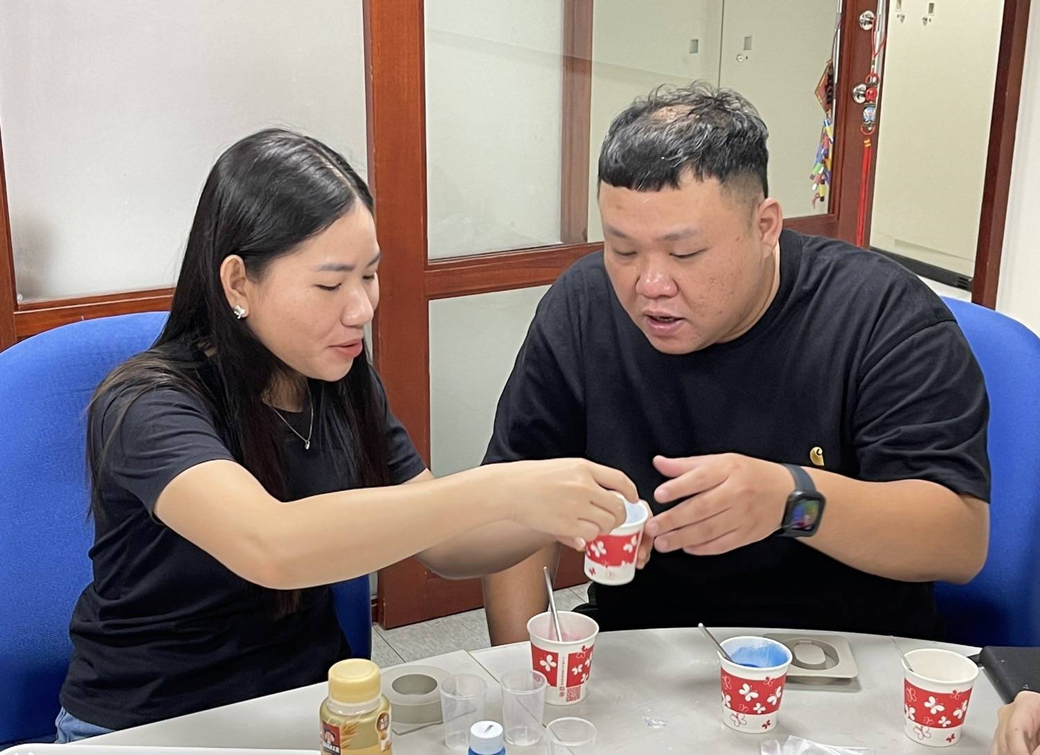 新住民小翠(左一)與其先生(右一)一同參與課程,圖為雙方正在專心凝製擴香石過程。