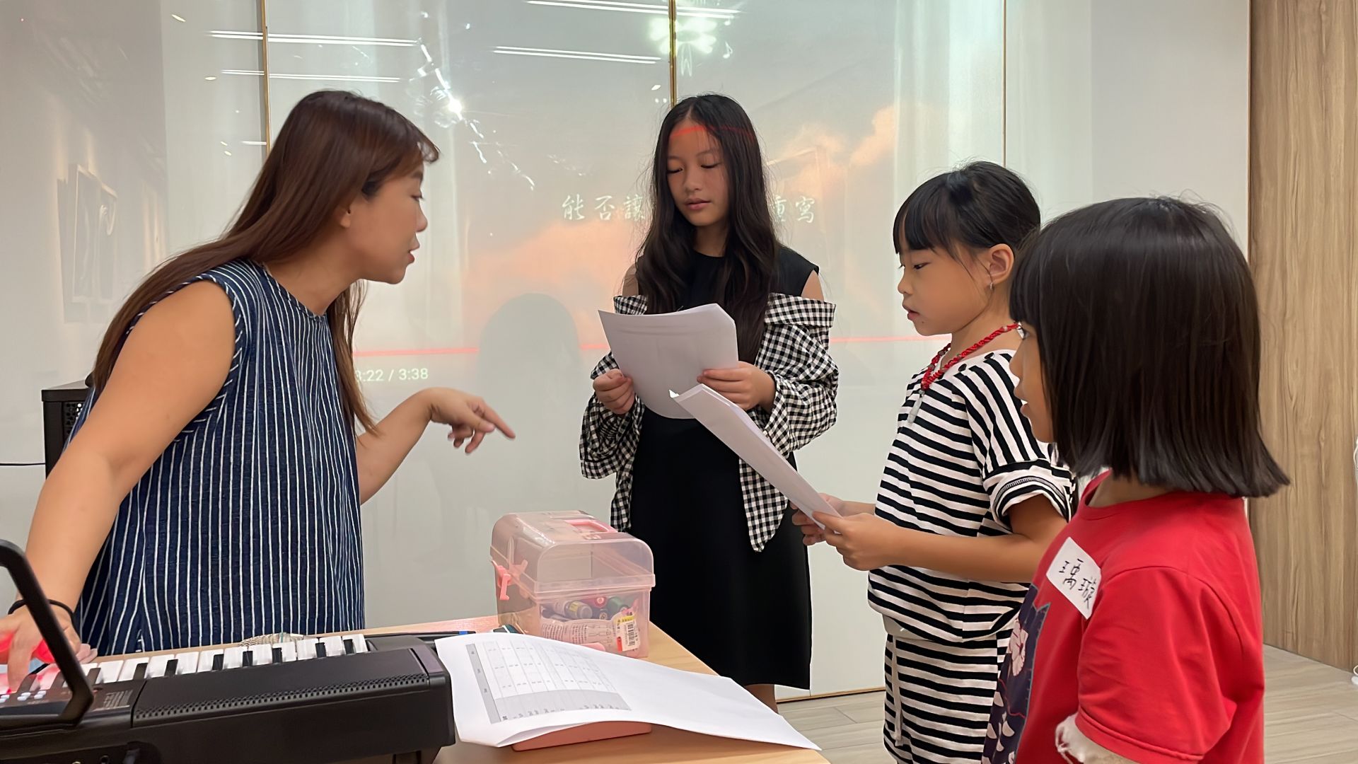 老師正在指導孩子們唱一部合聲