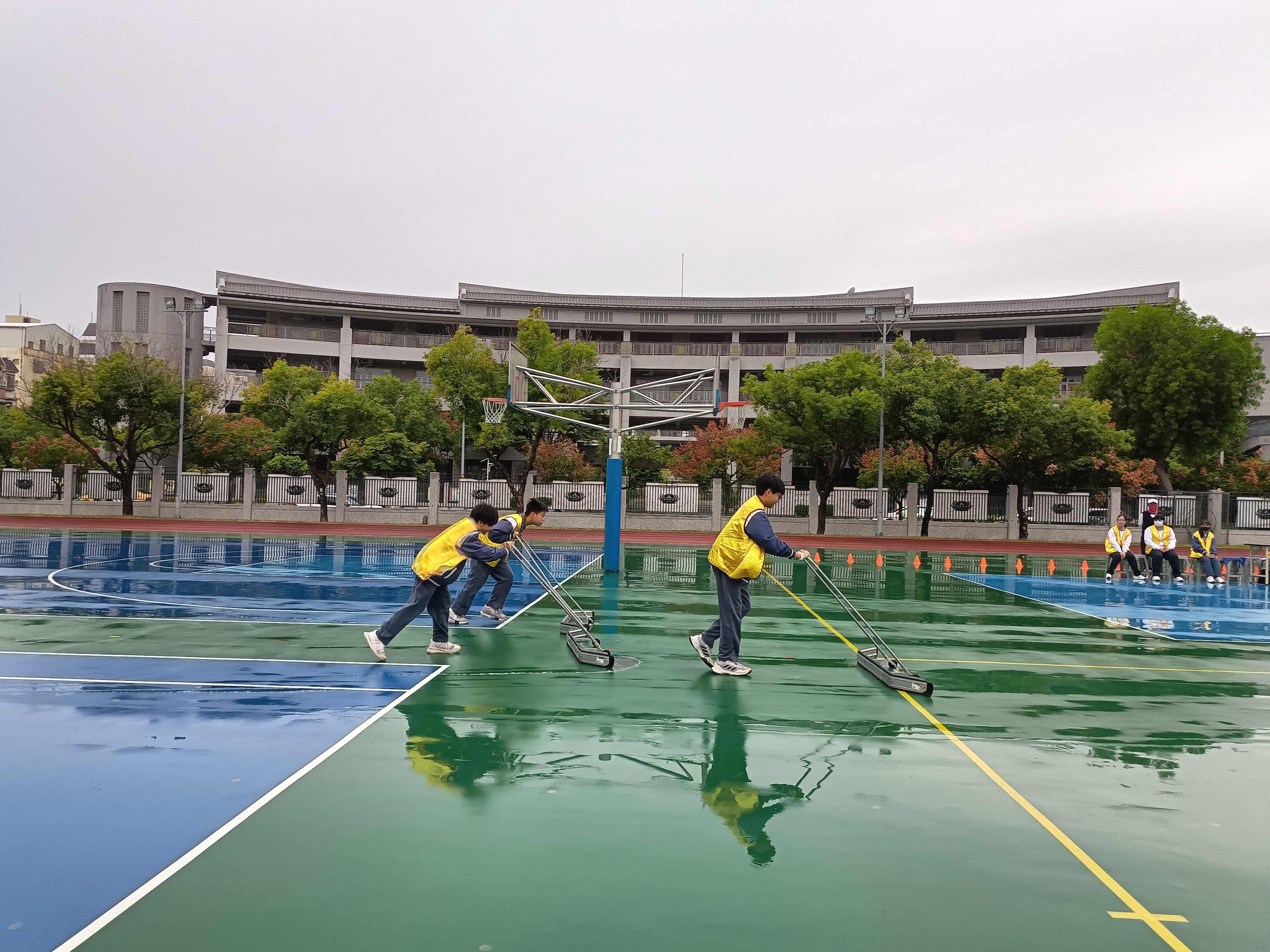 開賽前,志工同學努力清掃下雨的積水。